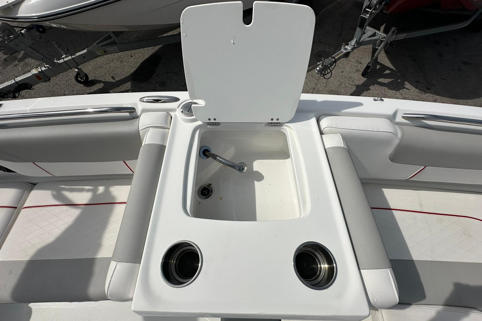 2021 Tahoe 2150 boat interior with open storage compartment and cup holders.