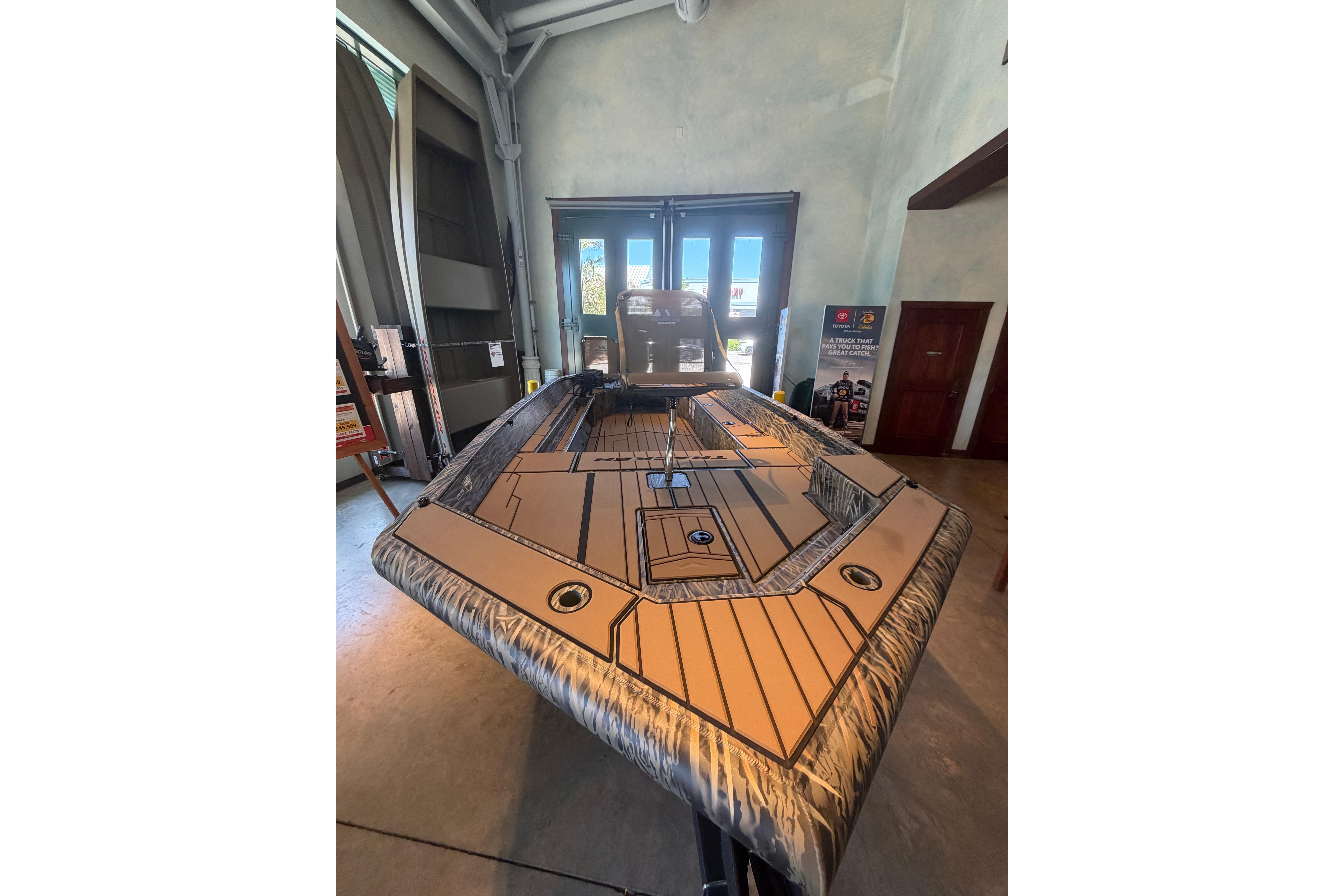 2026 Tracker Grizzly 1756 T Marsh boat displayed indoors, showcasing sleek design and spacious deck.