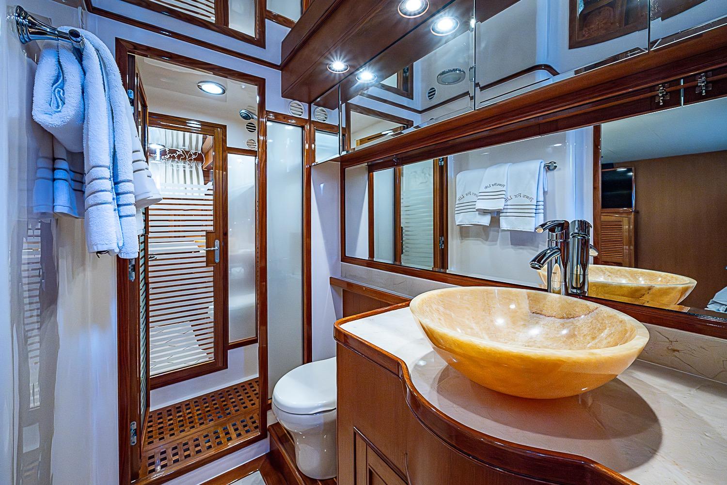 Luxurious Marlow 80 Explorer 2014 yacht bathroom with elegant sink and wooden accents.