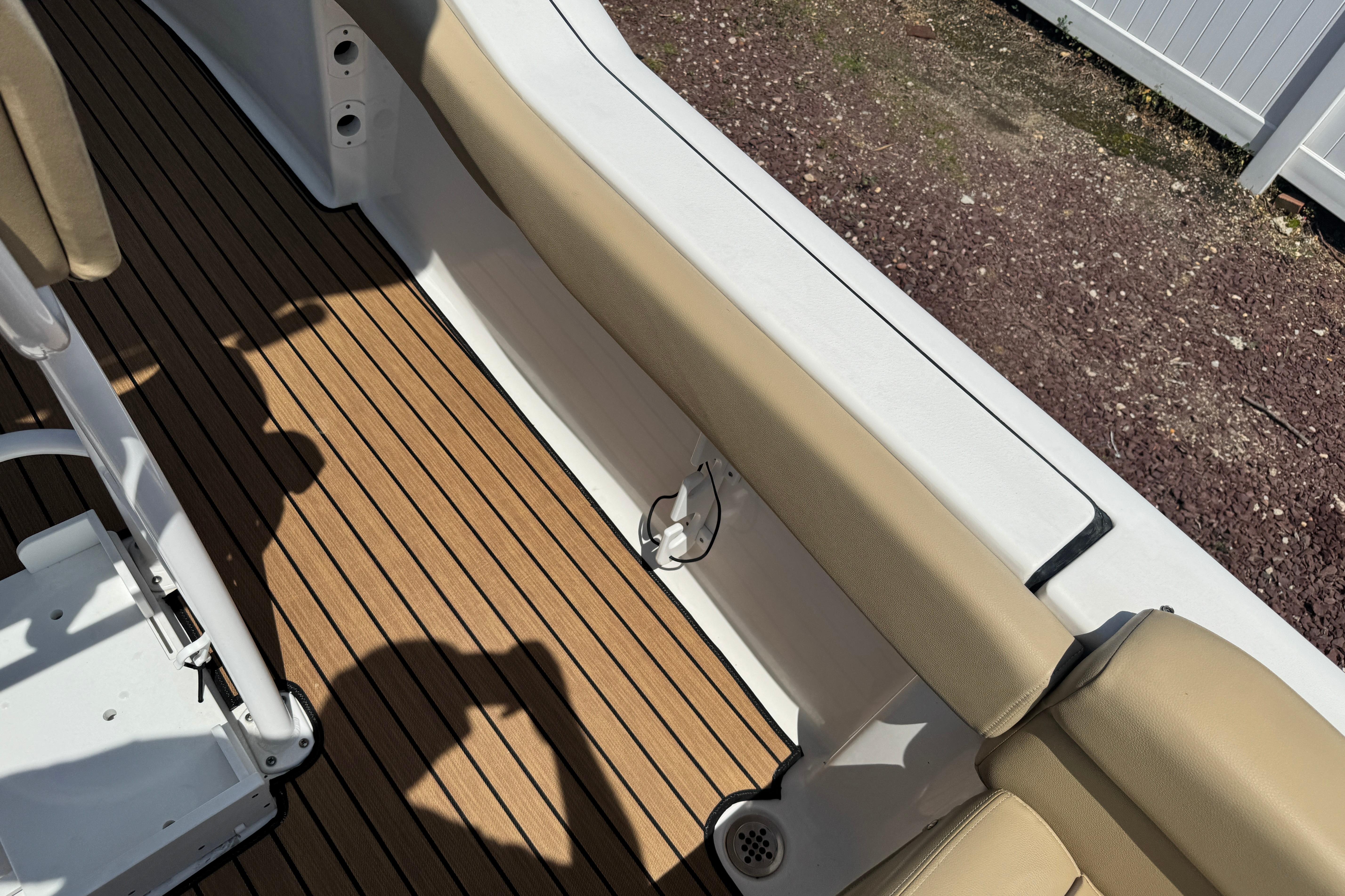 Interior view of 2016 Tidewater 230 LXF boat with tan seating and wooden flooring.