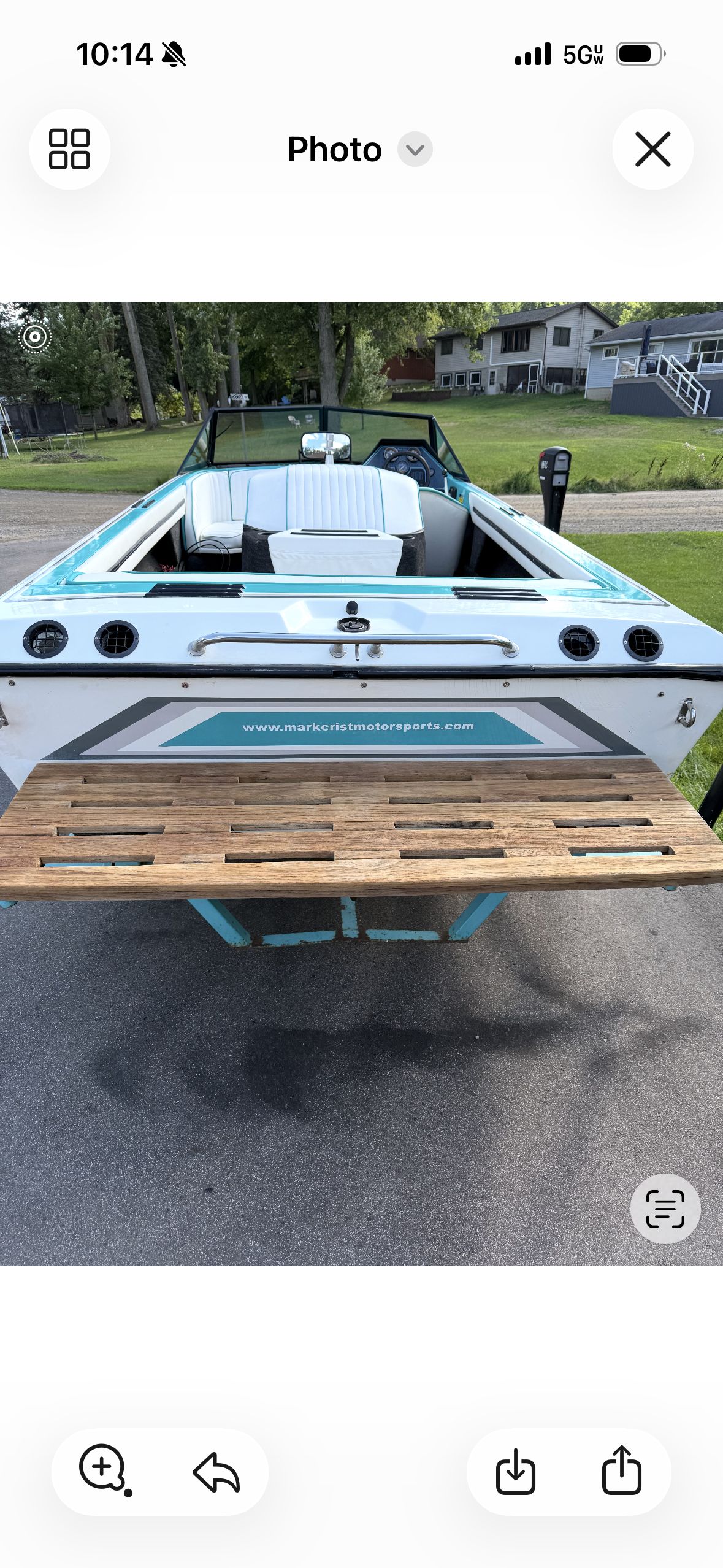 A 1992 Malibu Skier boat with white and blue design, parked on a driveway.