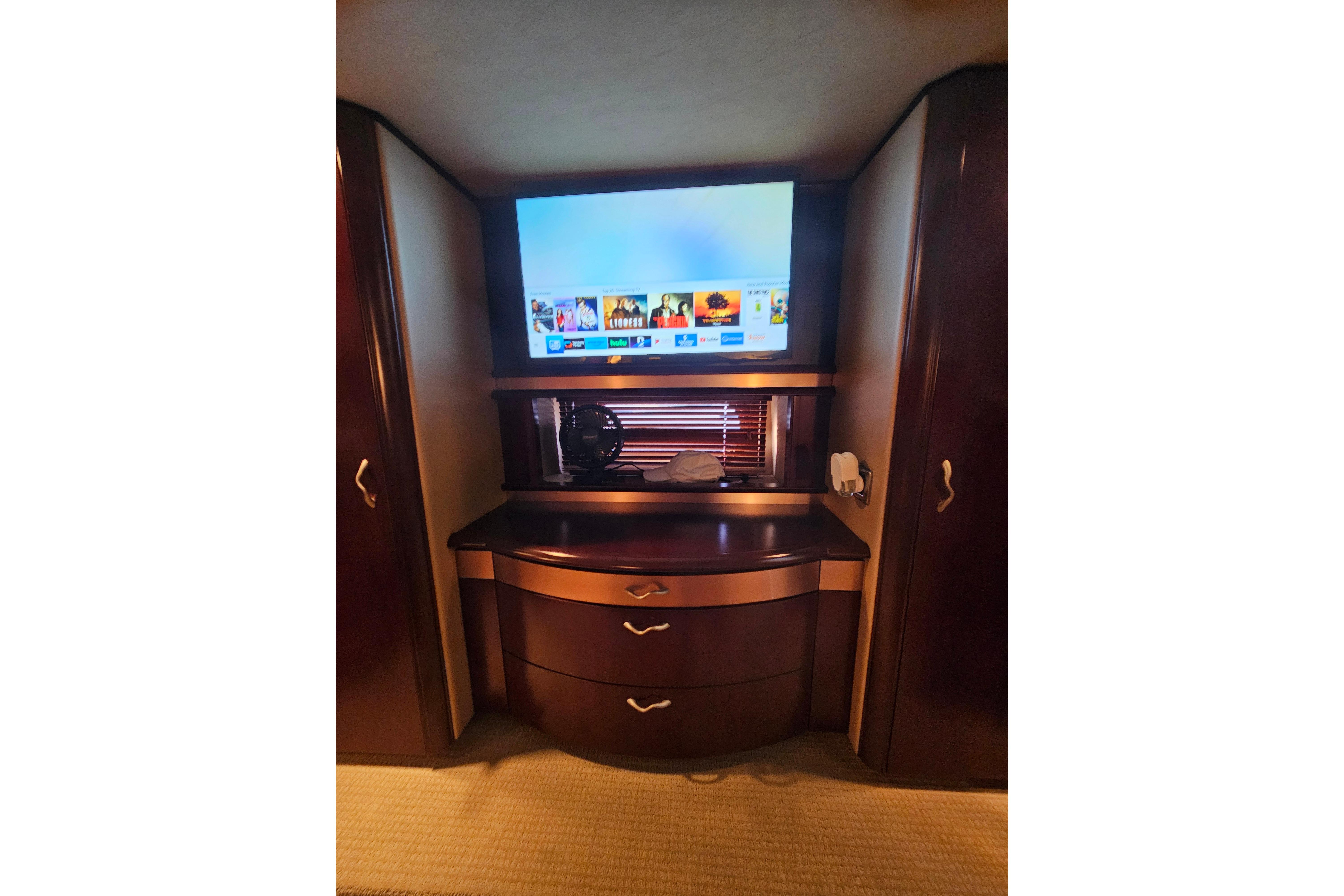 Luxurious interior of 2006 Sea Ray 580 Sedan Bridge with TV and elegant cabinetry.
