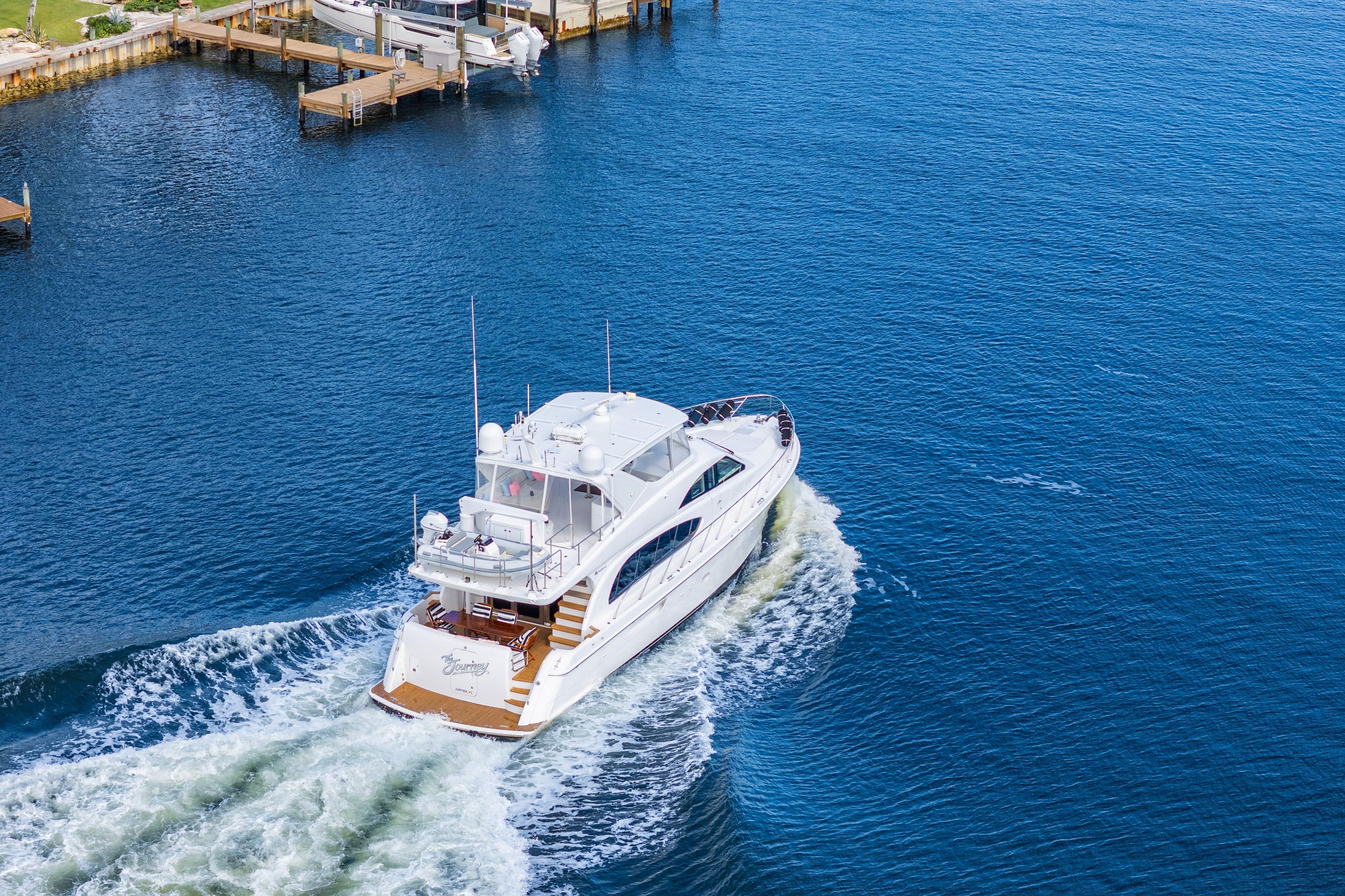 2008 Hatteras 64 Motor Yacht cruising on open water near docks.