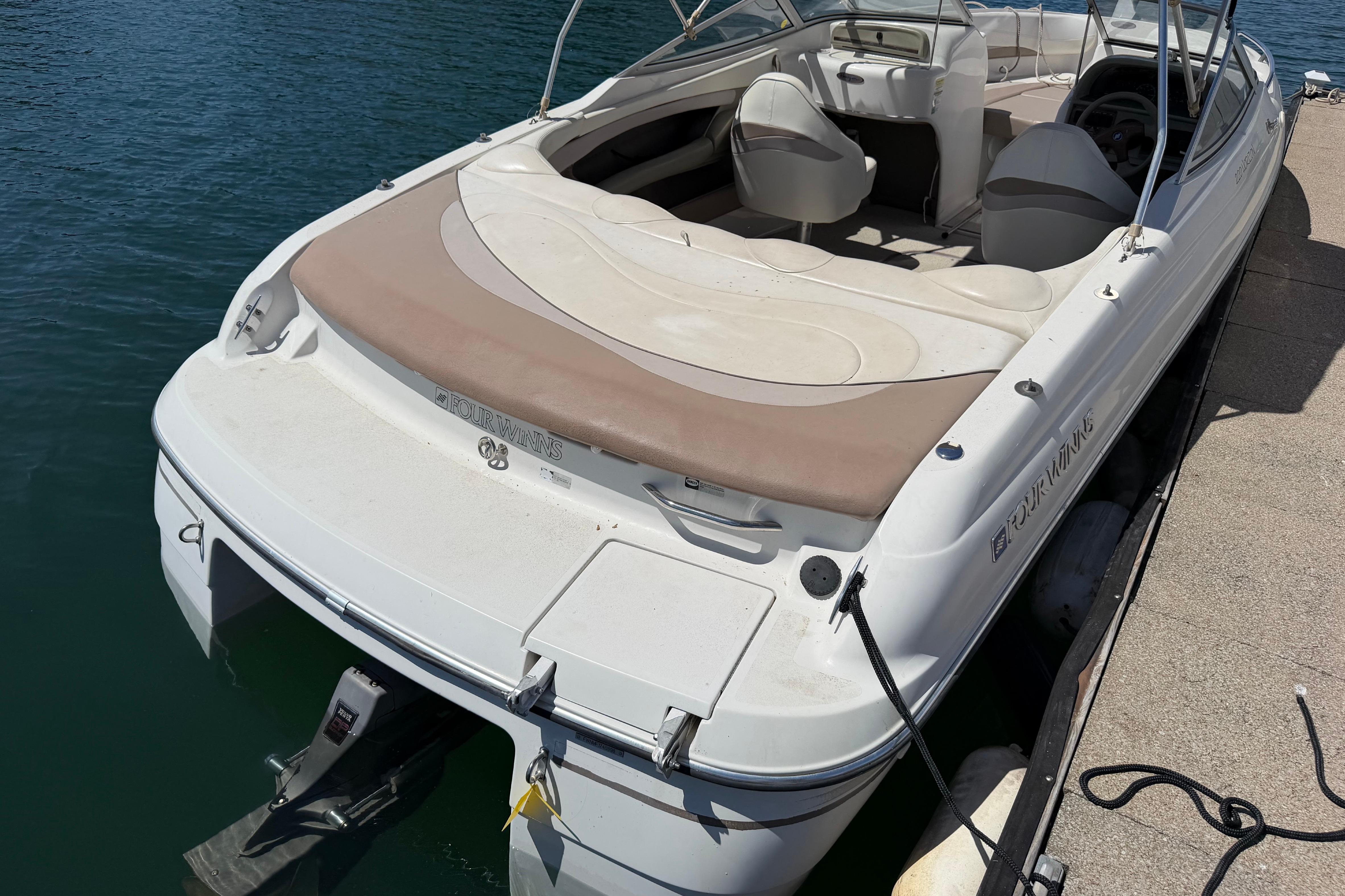 1998 Four Winns 220 Horizon boat docked on calm water.