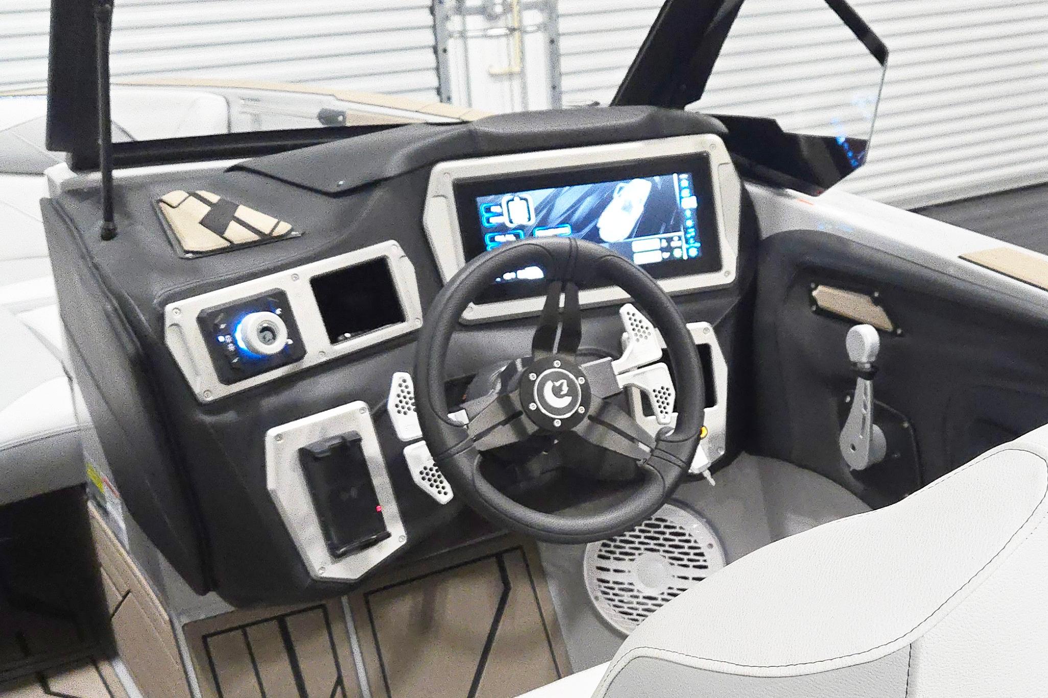Interior of a 2026 Centurion Nv243 boat featuring a modern dashboard and steering wheel.