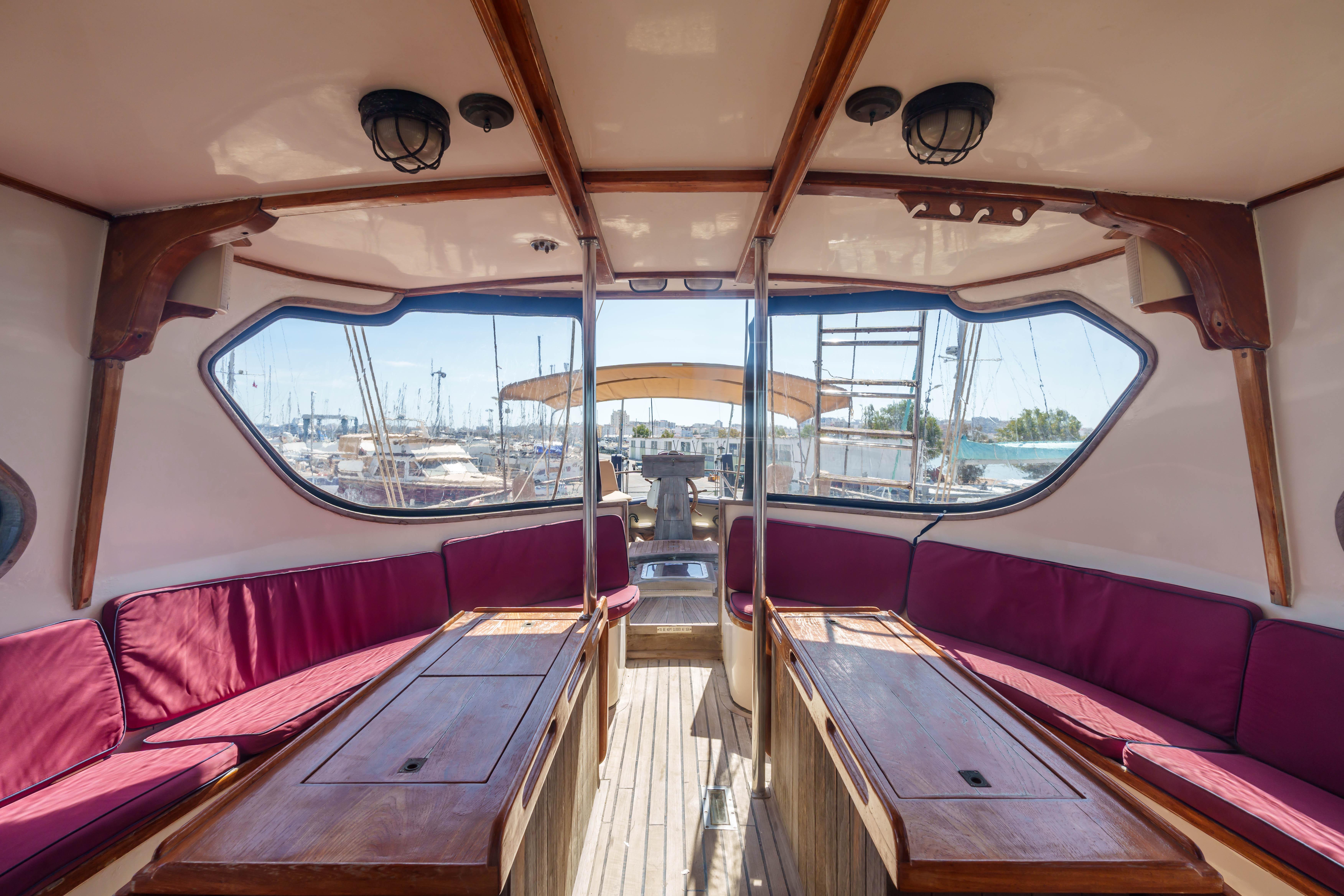 Interior of 1983 Cavalier Cavalier 92 yacht with red seating and wooden accents.