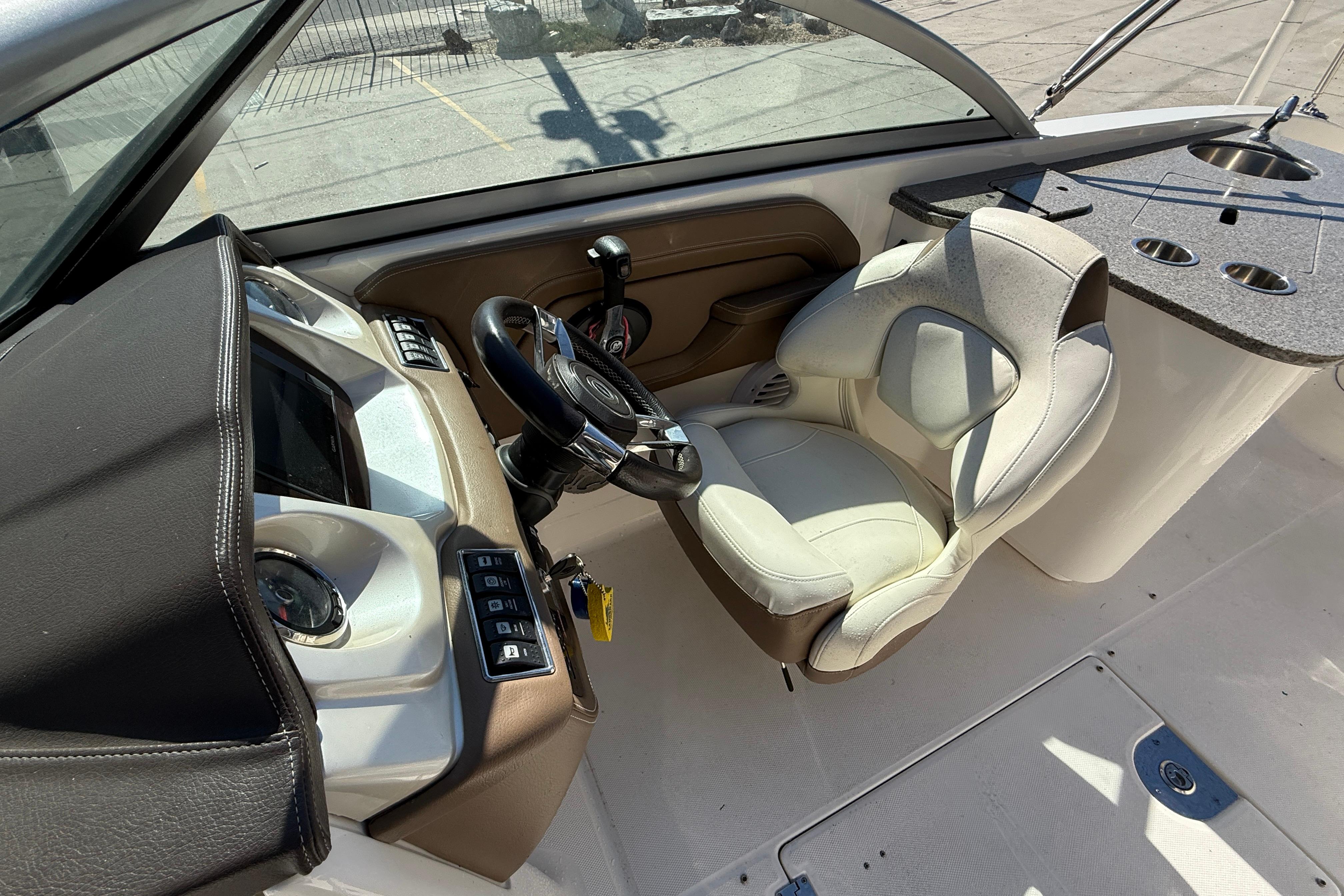 2014 Chaparral 264 Sunesta boat cockpit with steering wheel and control panel.