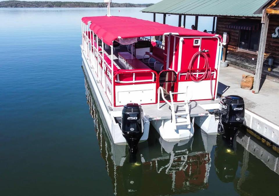 2024 Aloha Pontoon 50' Water Taxi with red canopy docked on calm water.