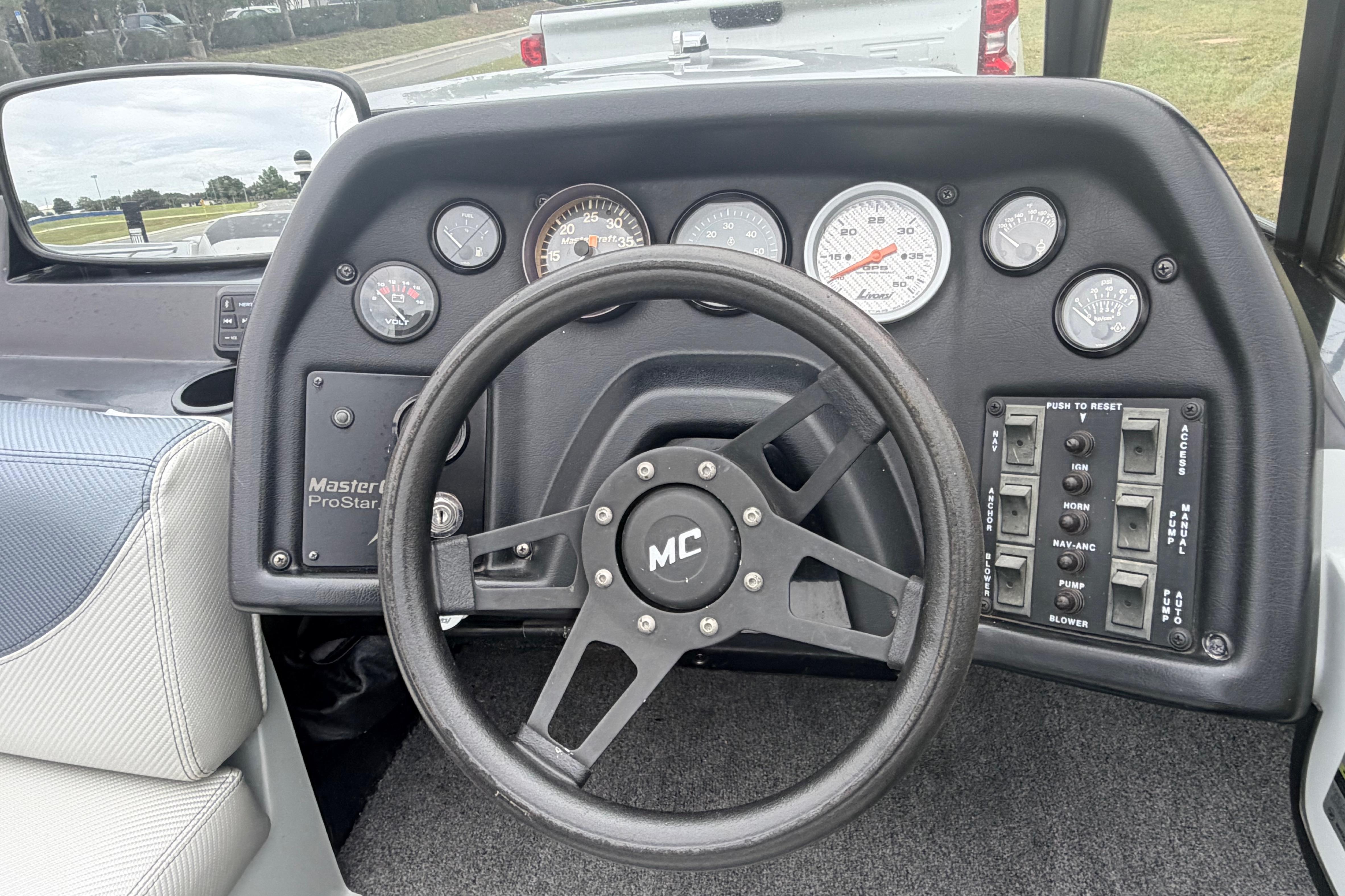 Dashboard of a 1989 MasterCraft ProStar 190 boat with steering wheel and gauges.