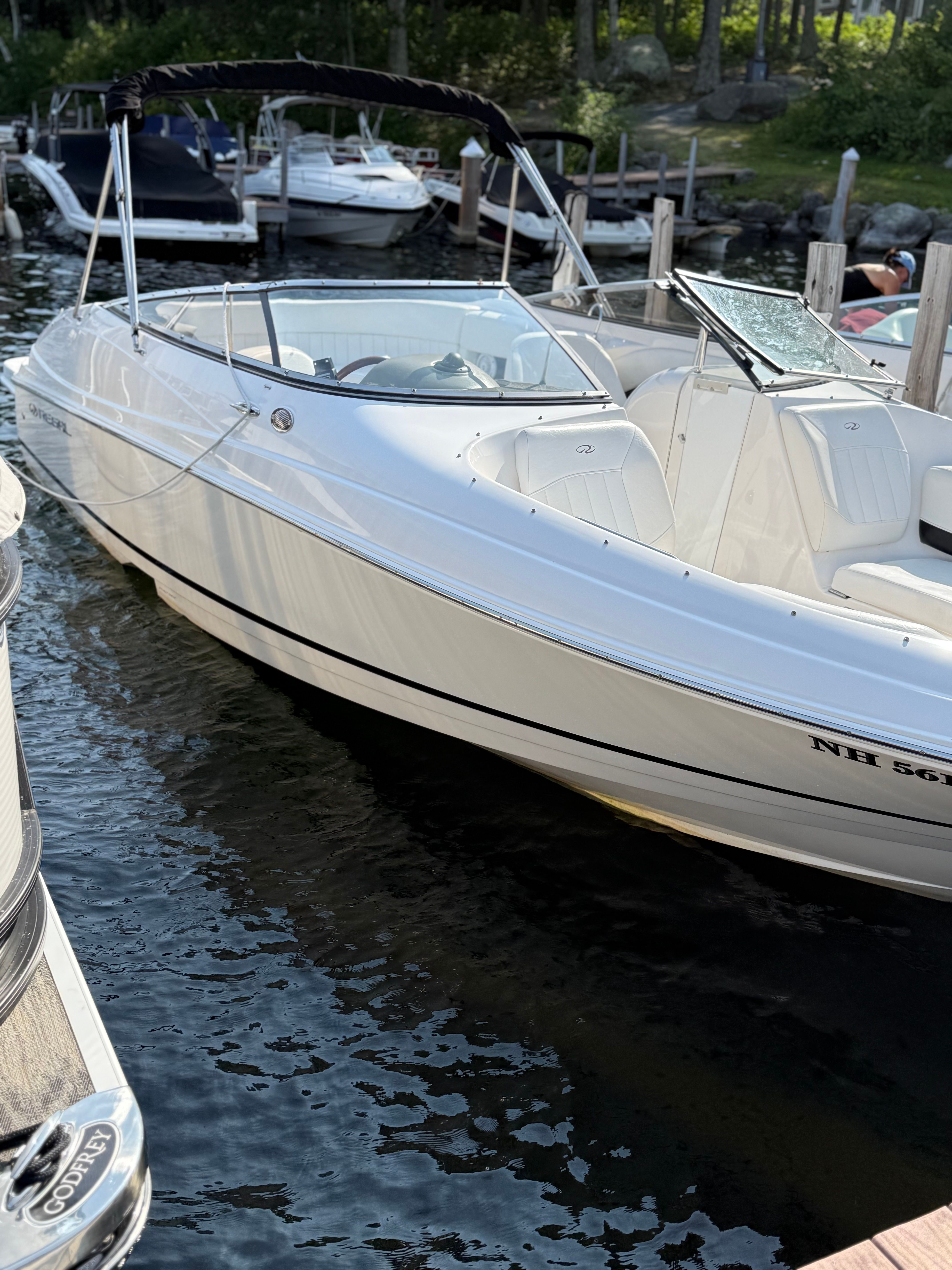 2007 Regal 2400 Bowrider boat docked in a marina, featuring sleek white design.