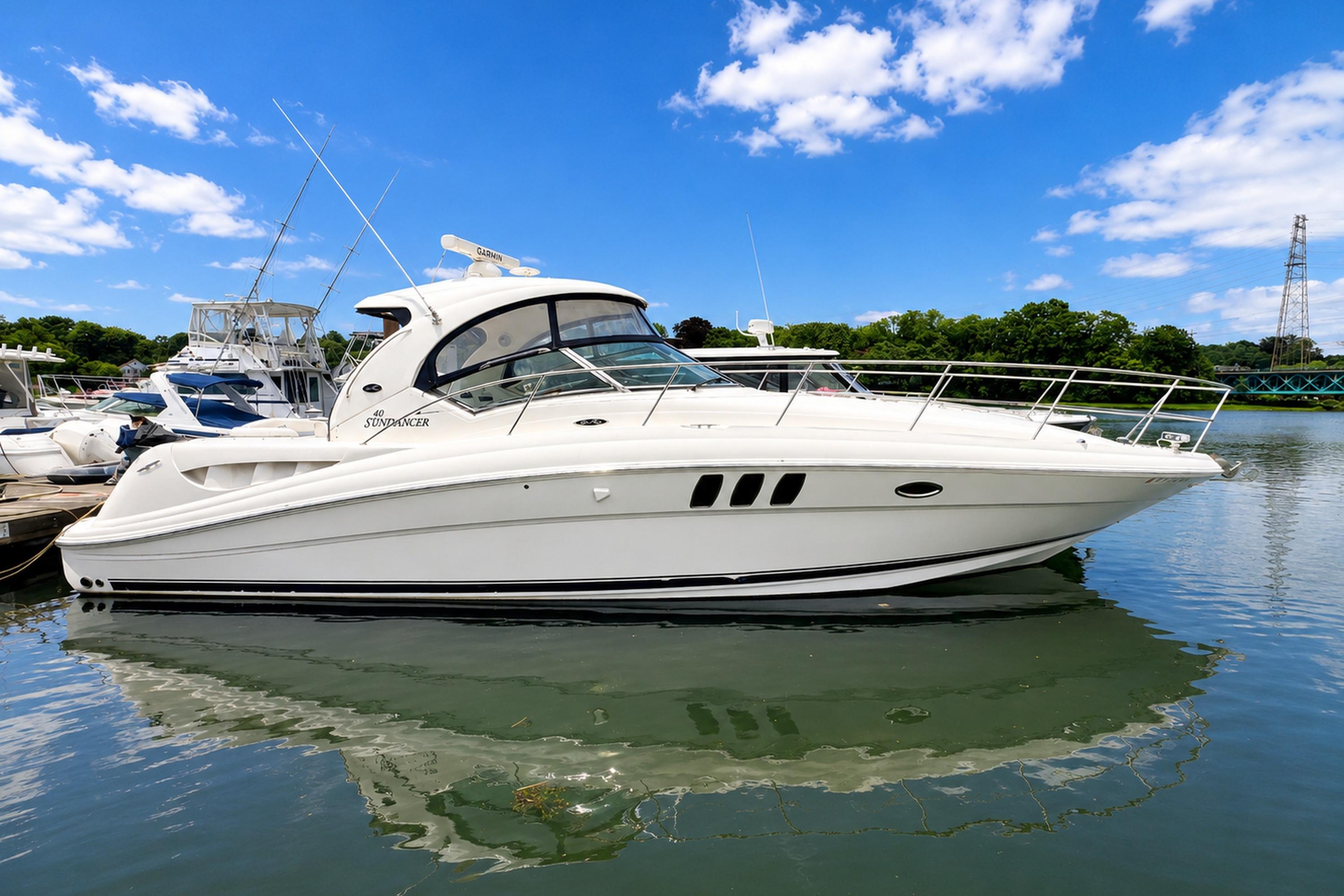 2006 Sea Ray 40 Sundancer docked in a marina, surrounded by other boats, under a blue sky.