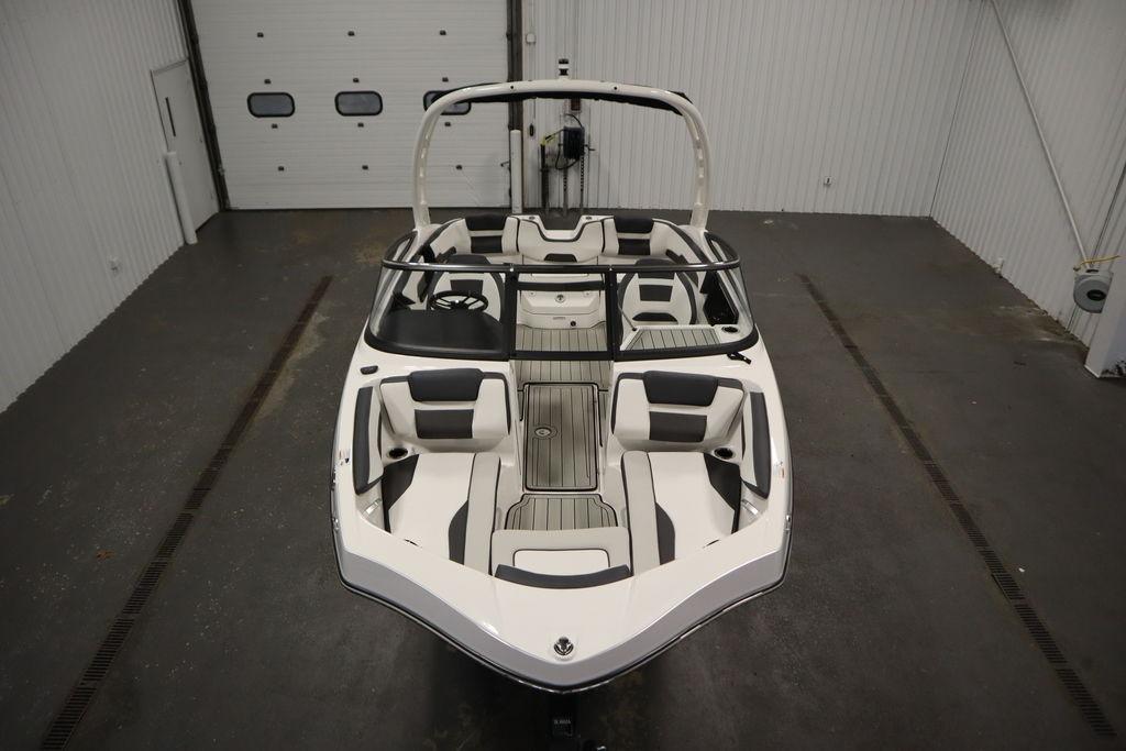 2026 Yamaha Boats 195S in a showroom, showcasing sleek design and spacious seating.