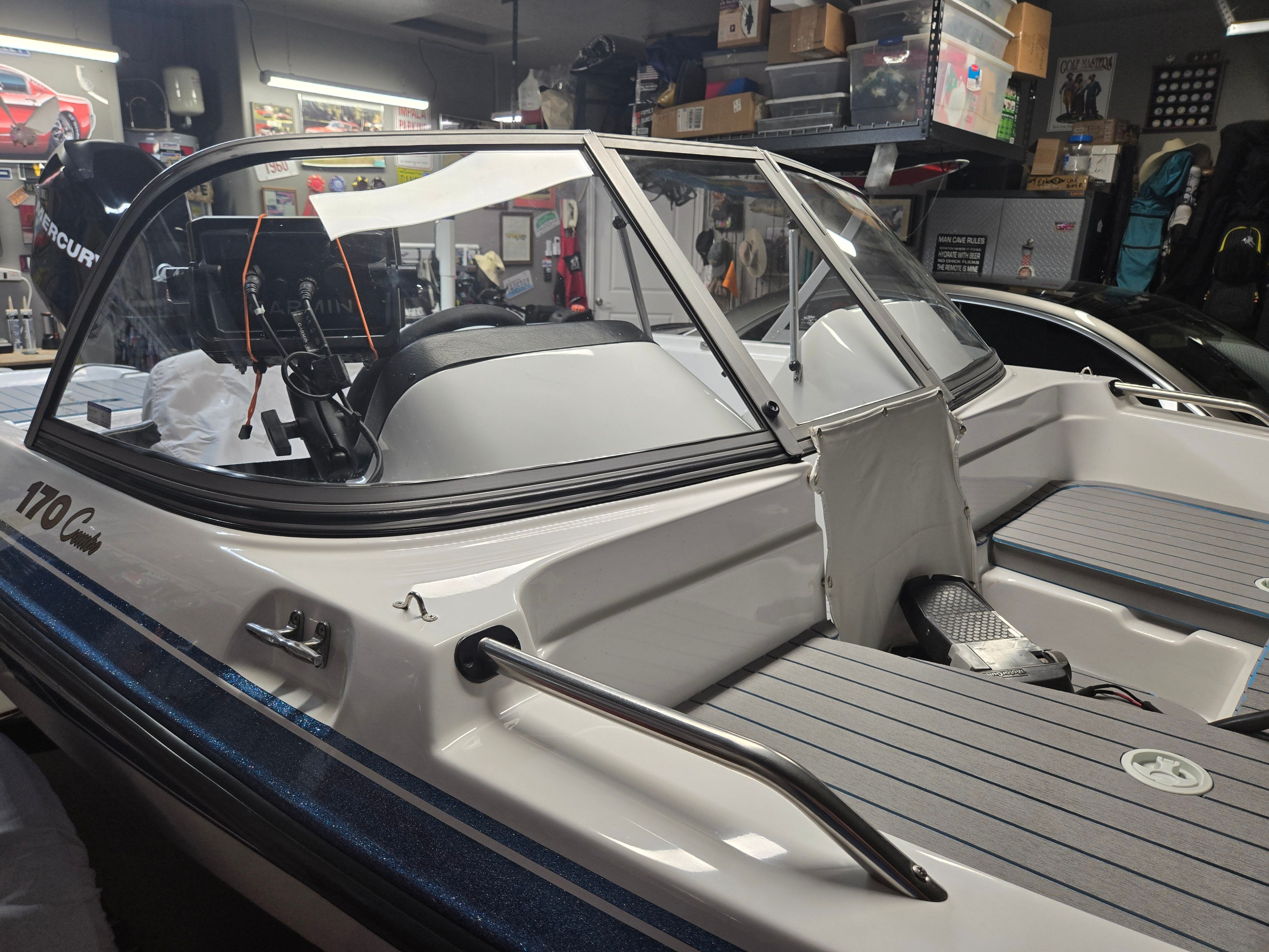 2007 ProCraft 170 Combo in a garage, featuring a blue stripe and windshield.