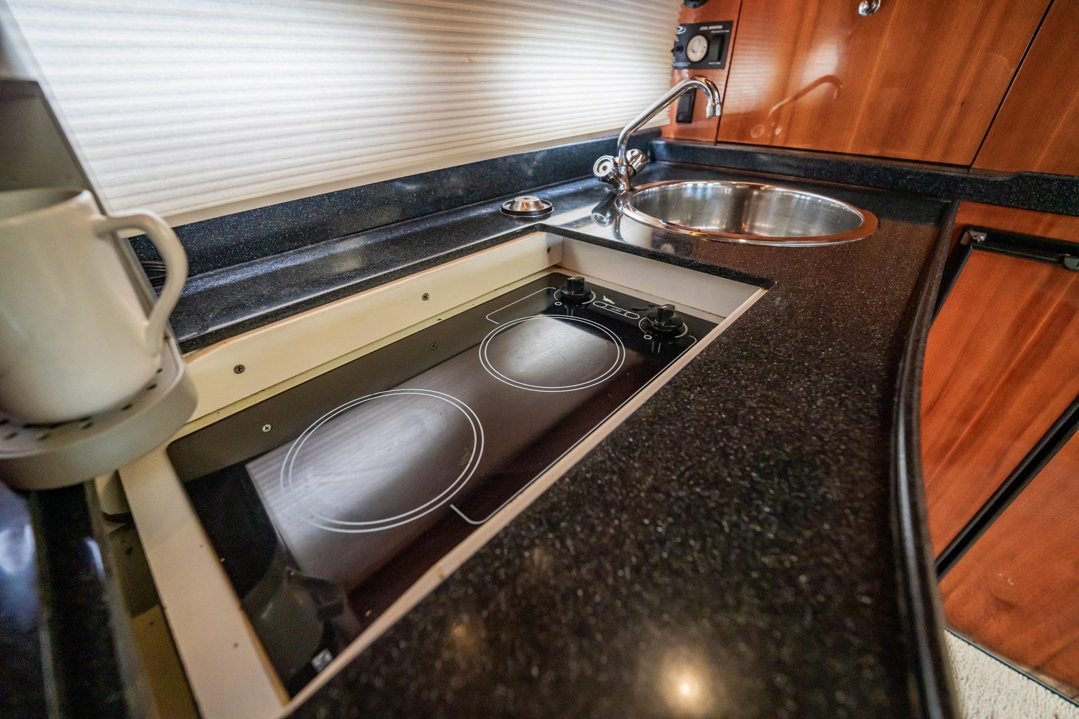 2008 Regal Commodore 4460 yacht kitchen with stove, sink, and countertop.