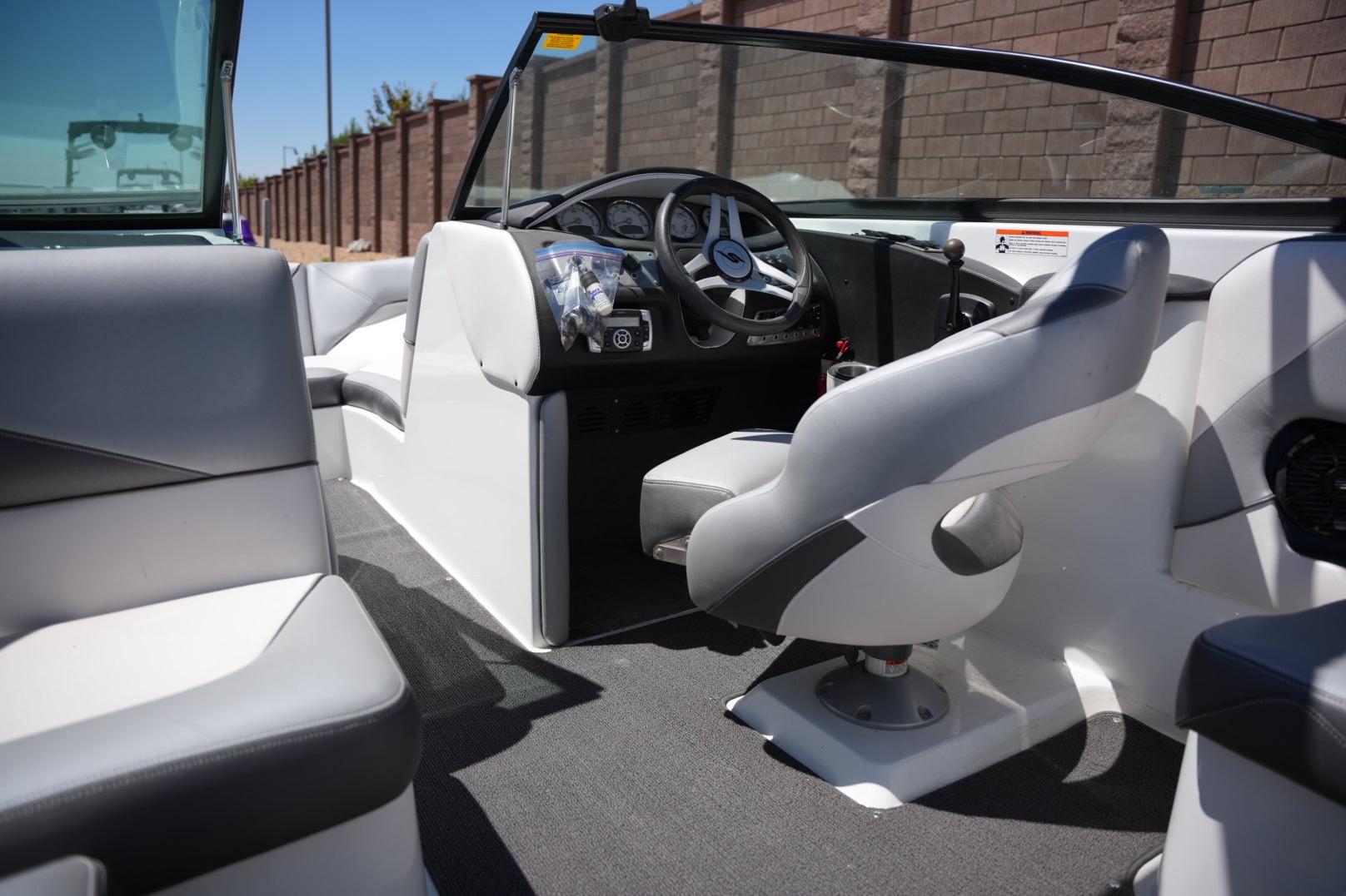 Interior of a 2016 Supreme S211 boat, featuring sleek seating and modern dashboard.