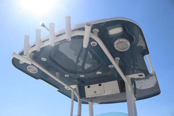 2023 Sea Pro 239 Center Console T-top with rod holders under clear blue sky.