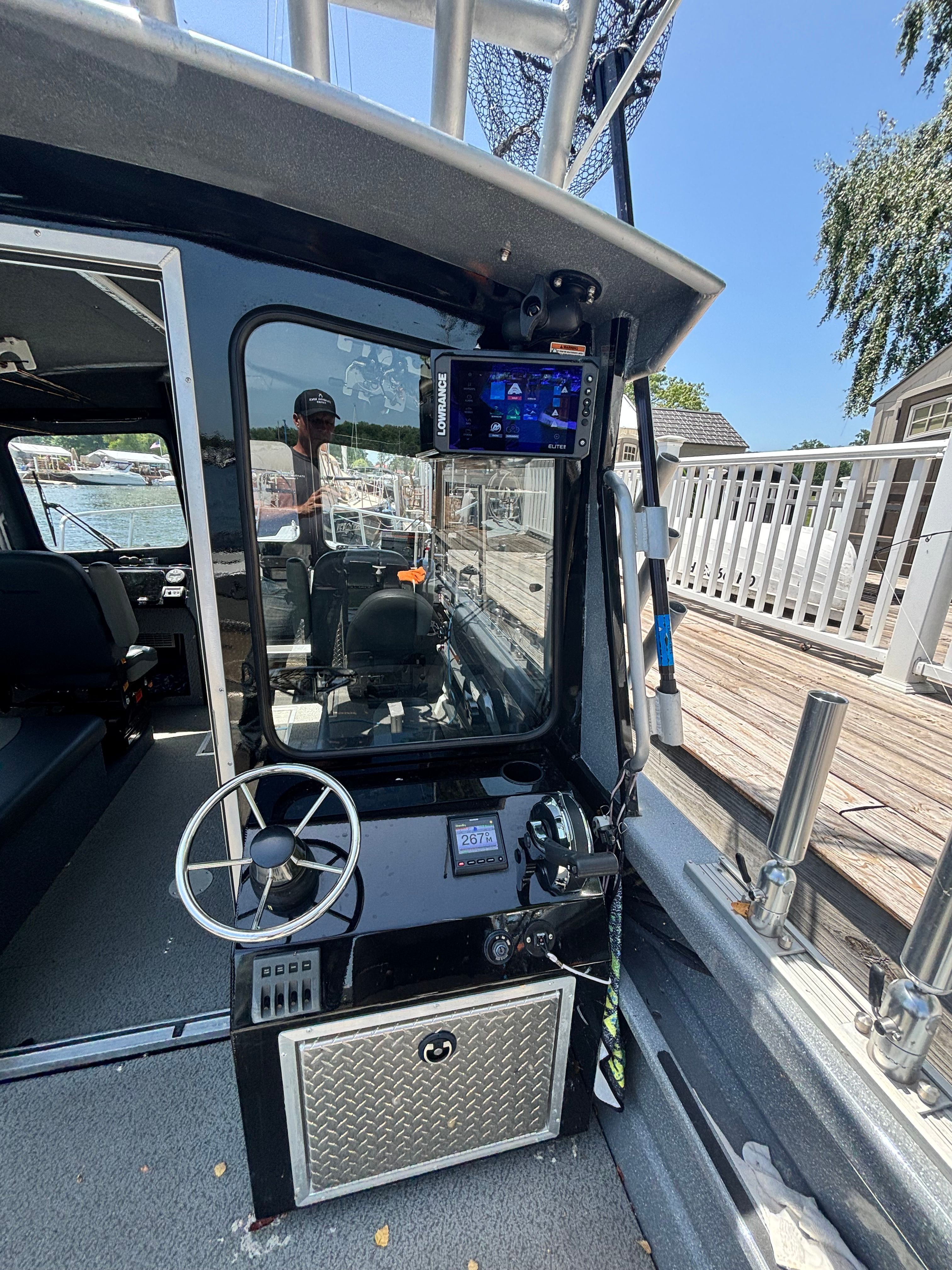 The image shows the cockpit of a 2021 Spartan 240 Maximus boat docked at a pier.