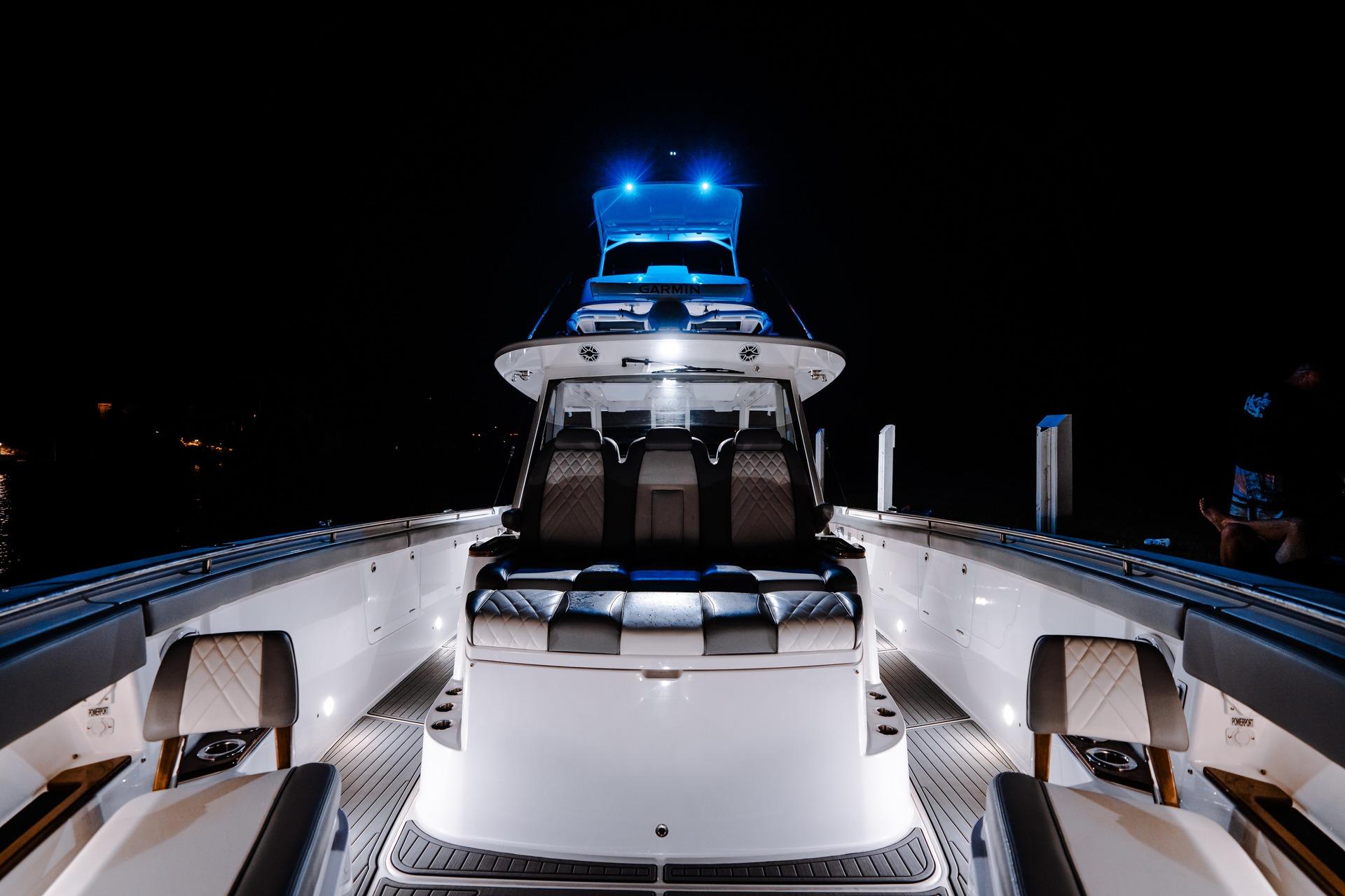 2026 Everglades 455 Center Console boat illuminated at night, showcasing luxury seating and sleek design.
