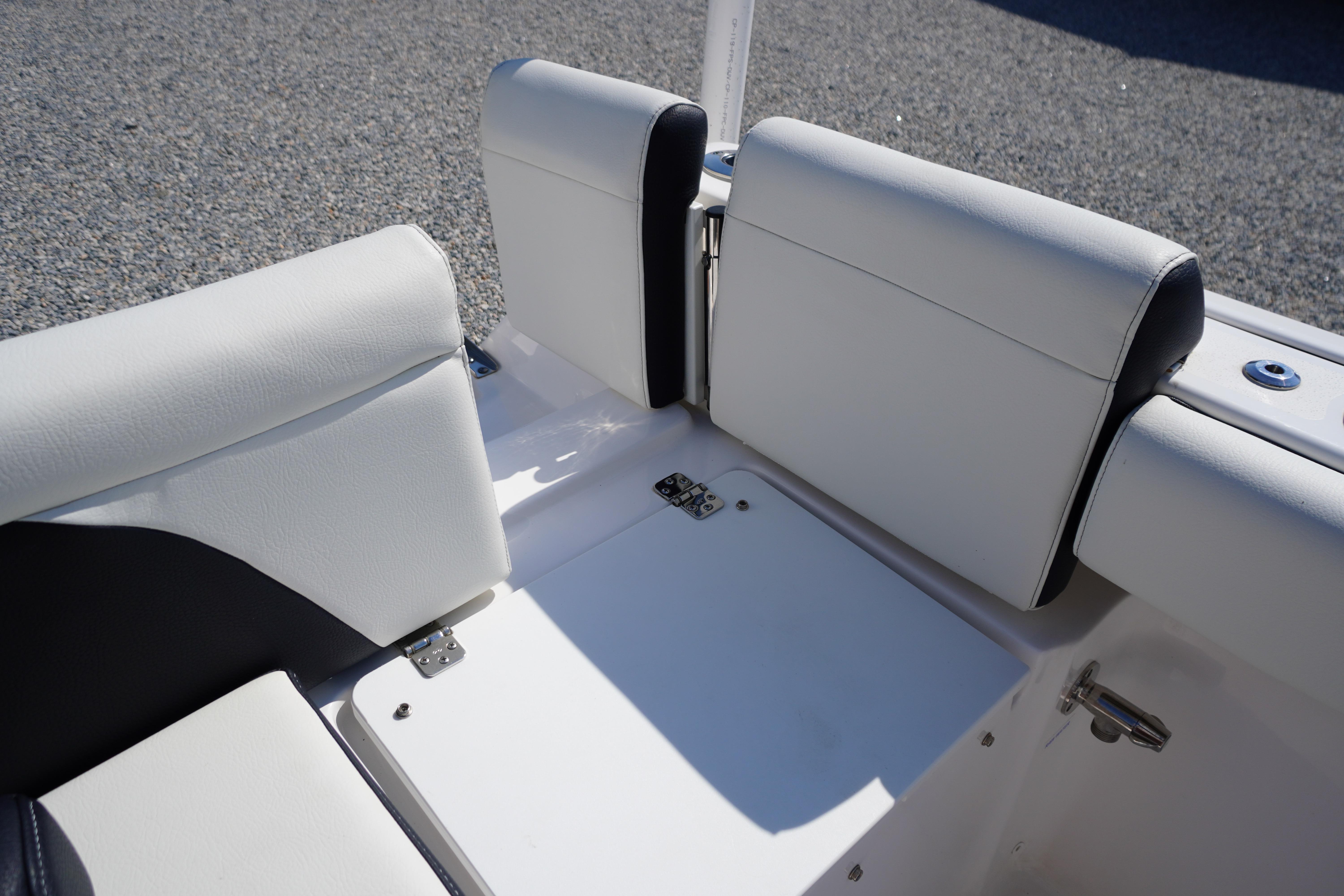 2025 Tidewater 232 SS boat seating area with white upholstery and storage compartment.