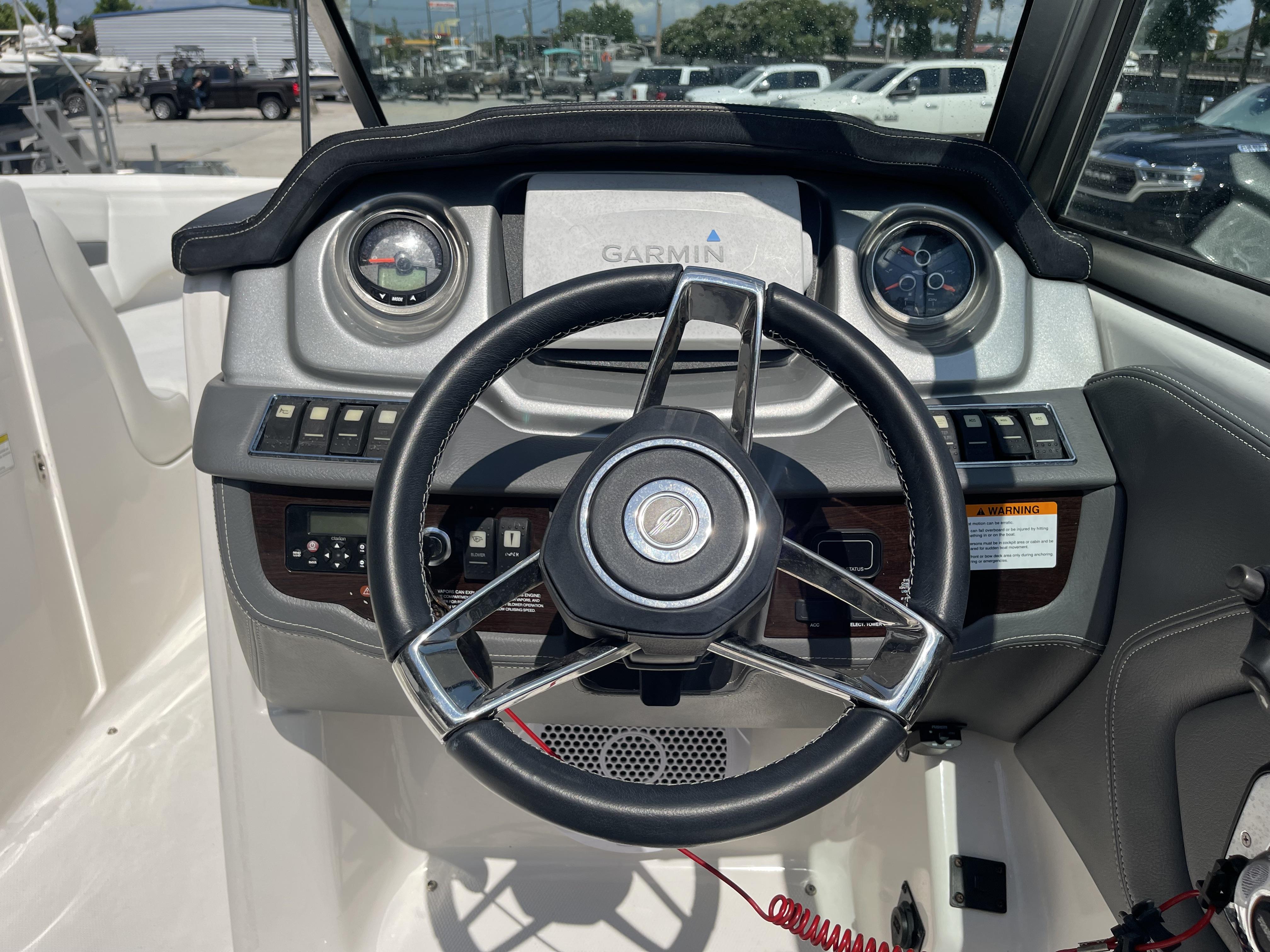 2014 Chaparral Sunesta 224 boat dashboard with Garmin navigation system and steering wheel.