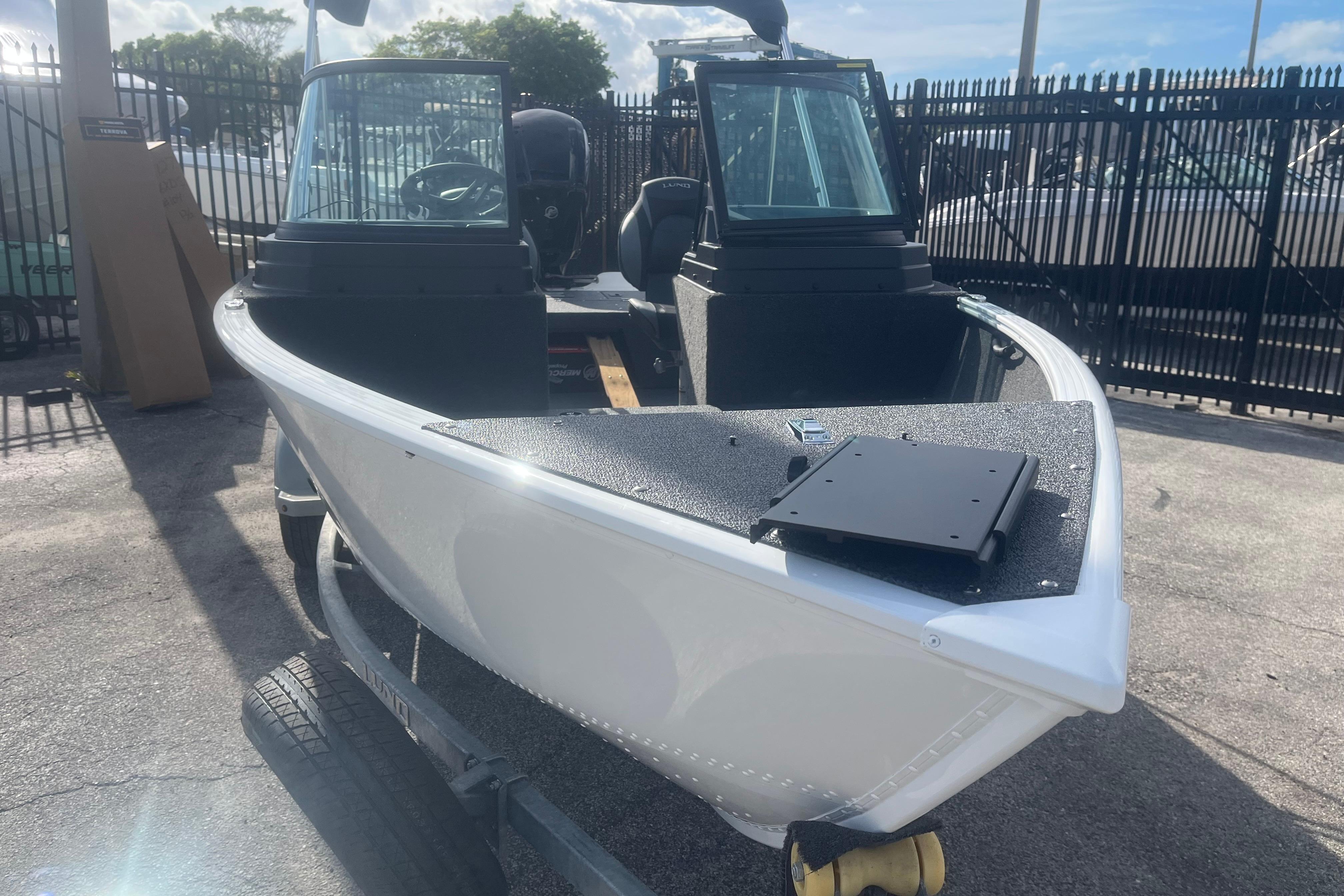 2026 Lund 1650 Rebel XL Sport boat on trailer, parked outdoors.