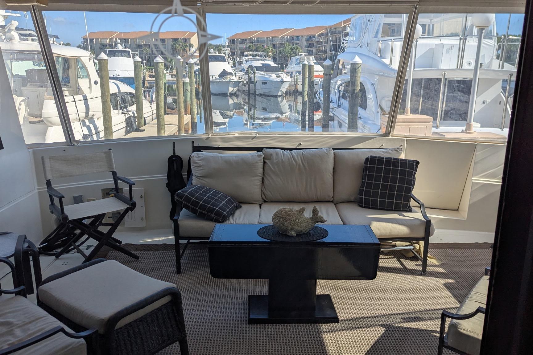 Interior of 1992 Viking 65 Motor Yacht with comfortable seating and marina view.