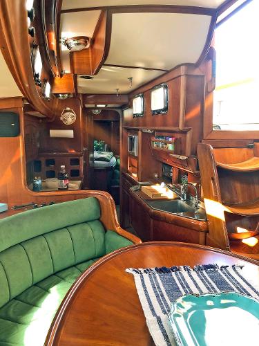 Interior of a 1988 Little Harbor 53 with wood finish and green upholstery.