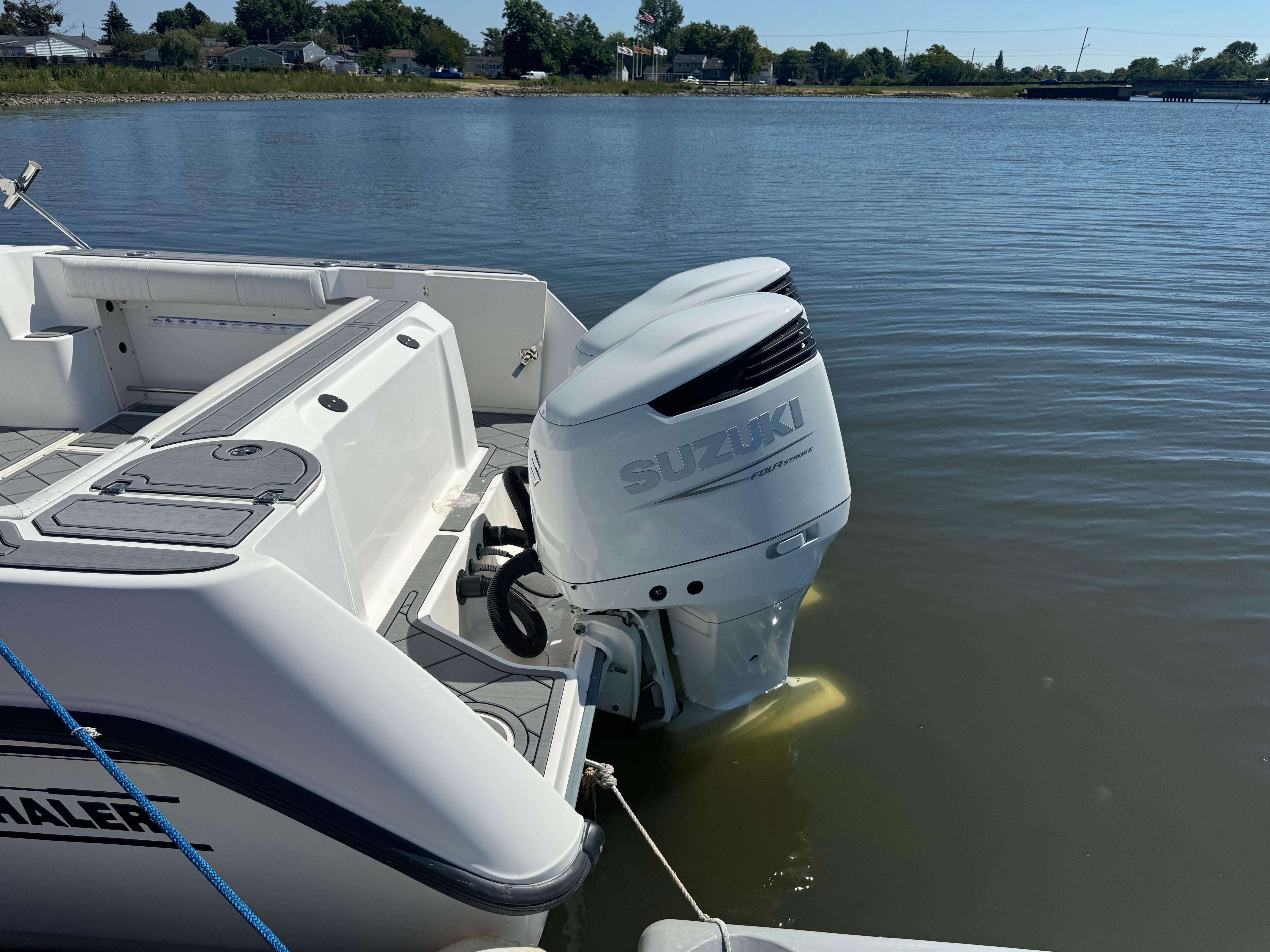 Boston Whaler 275 Conquest 2002 with Suzuki outboard motor on calm water.