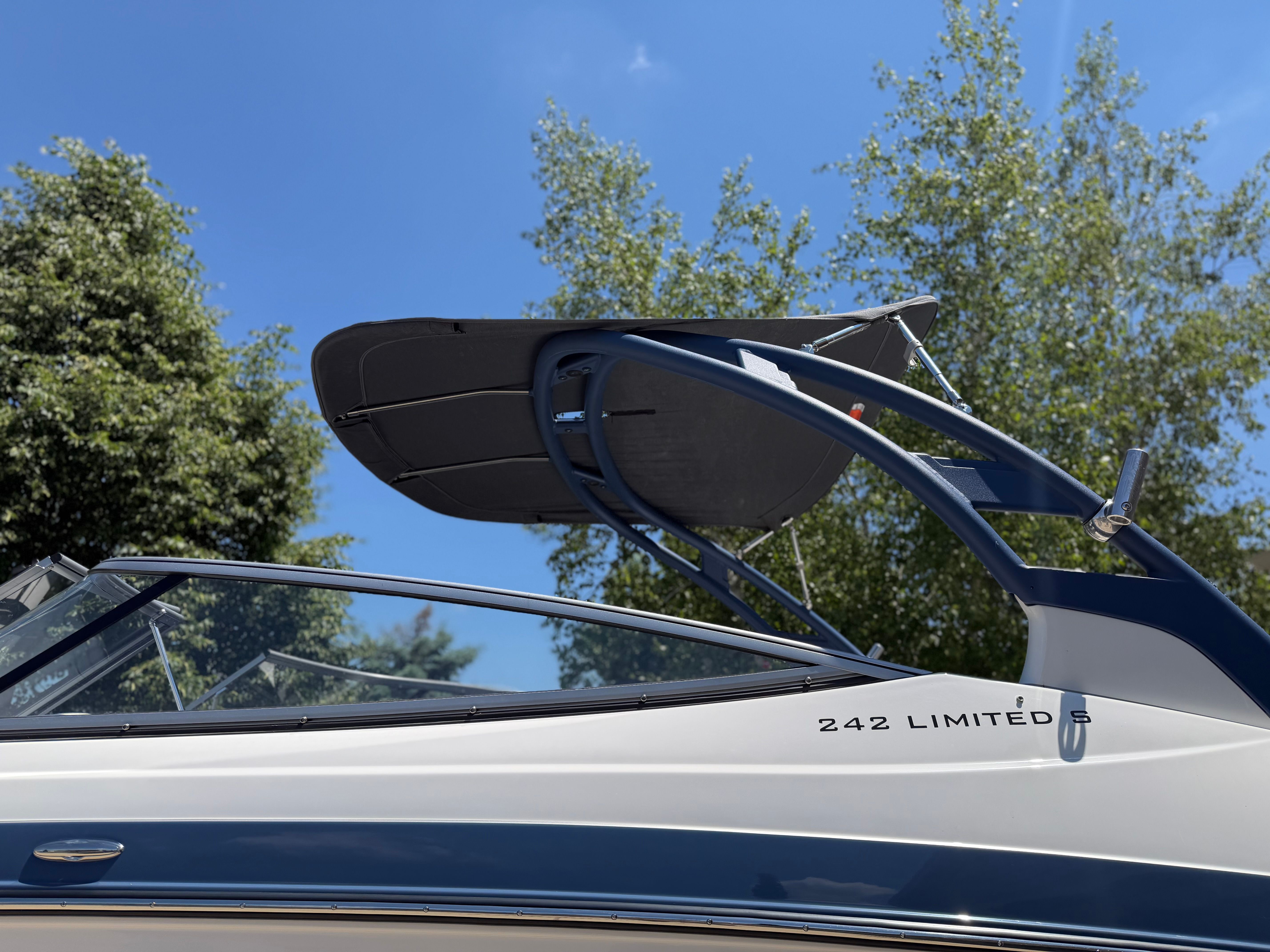 A 2018 Yamaha 242 Limited S boat with a sleek blue Bimini top.