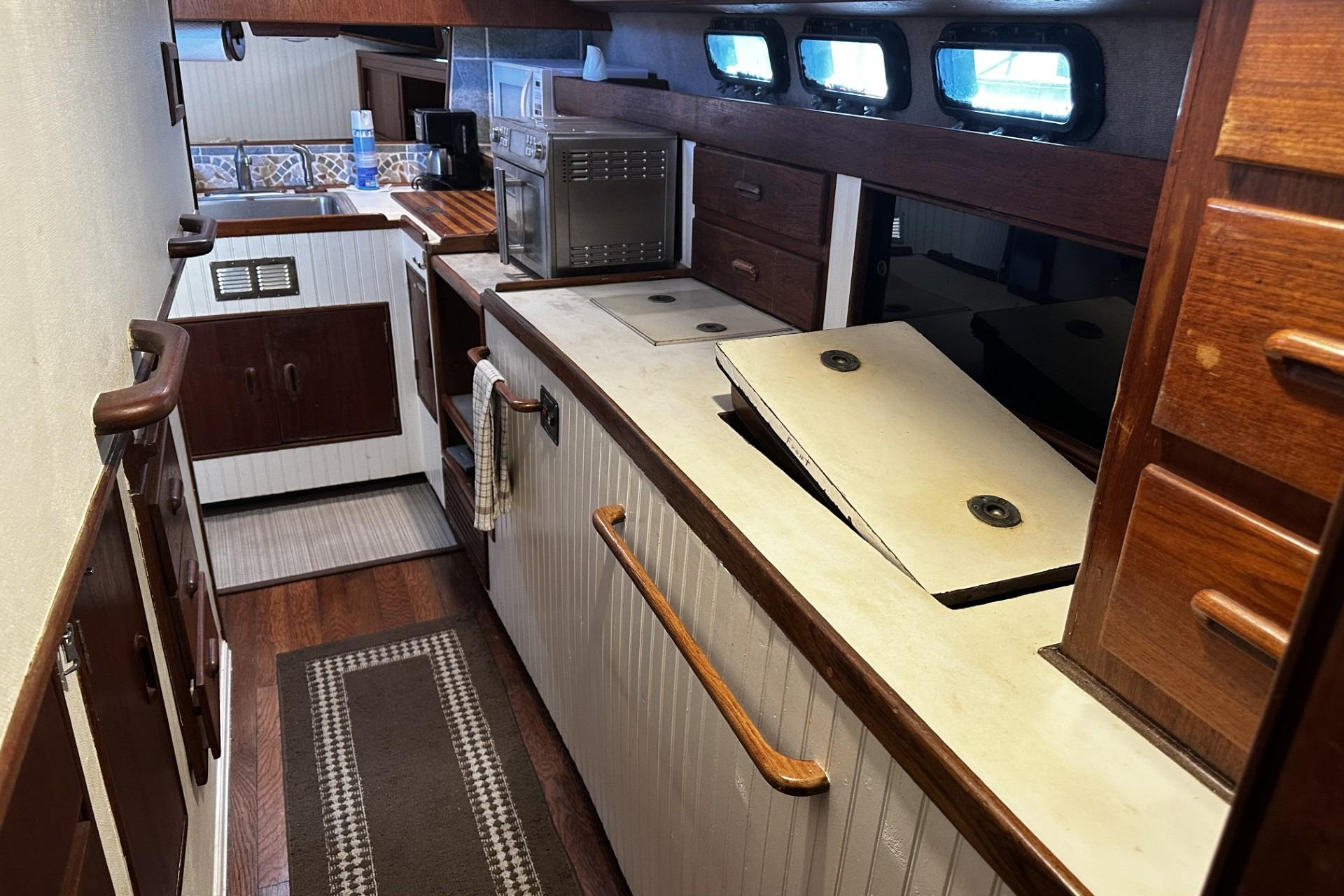 1975 Morgan Out Island 51 yacht interior with wooden cabinetry and kitchen appliances.