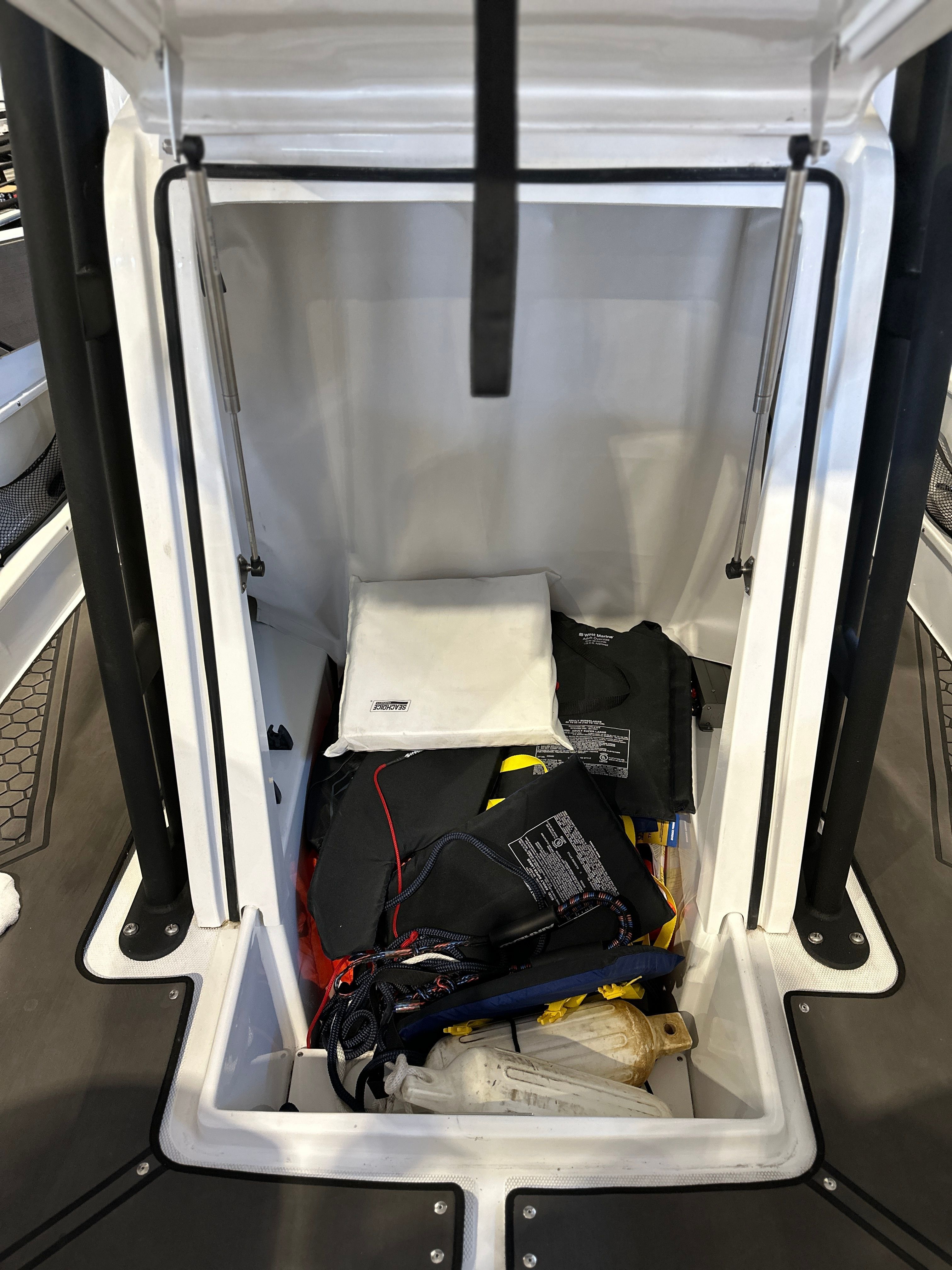 Storage compartment in Scarab 255 Open ID boat with life jackets and gear.