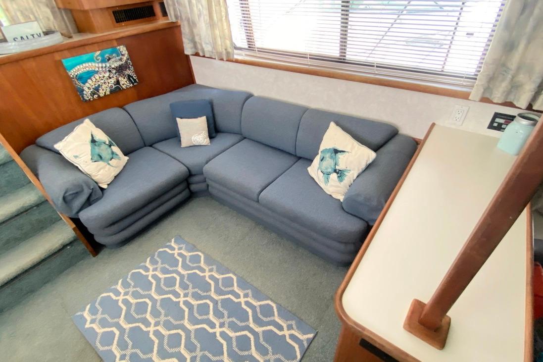 1992 Carver 36 Aft Cabin interior with blue sectional sofa and nautical decor.
