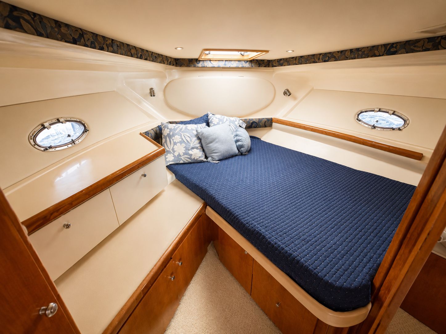 Cabin of the 2001 Carver 350 Mariner with a cozy bed and portholes.