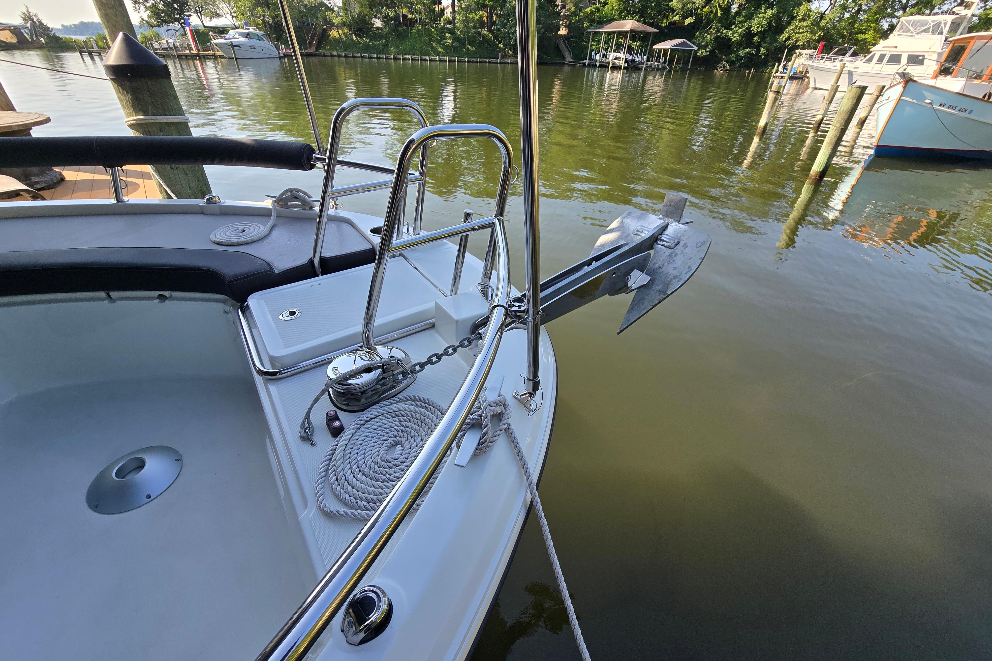 Bow of a Jeanneau NC Sport 895 with anchor and rope on calm water.
