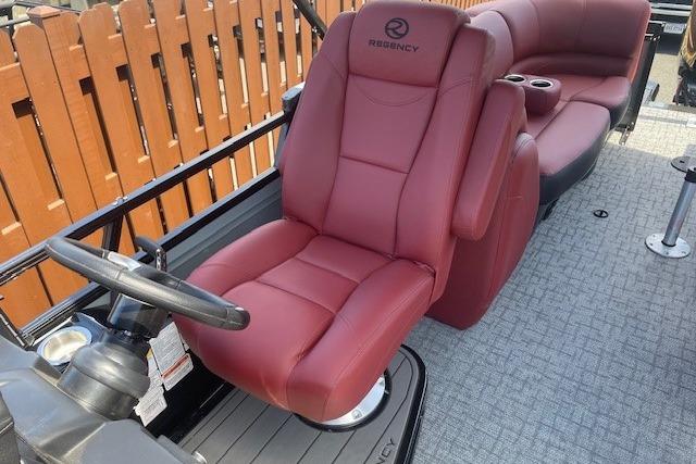 Luxurious 2026 Regency 250 DL boat interior with plush red seating and modern steering console.