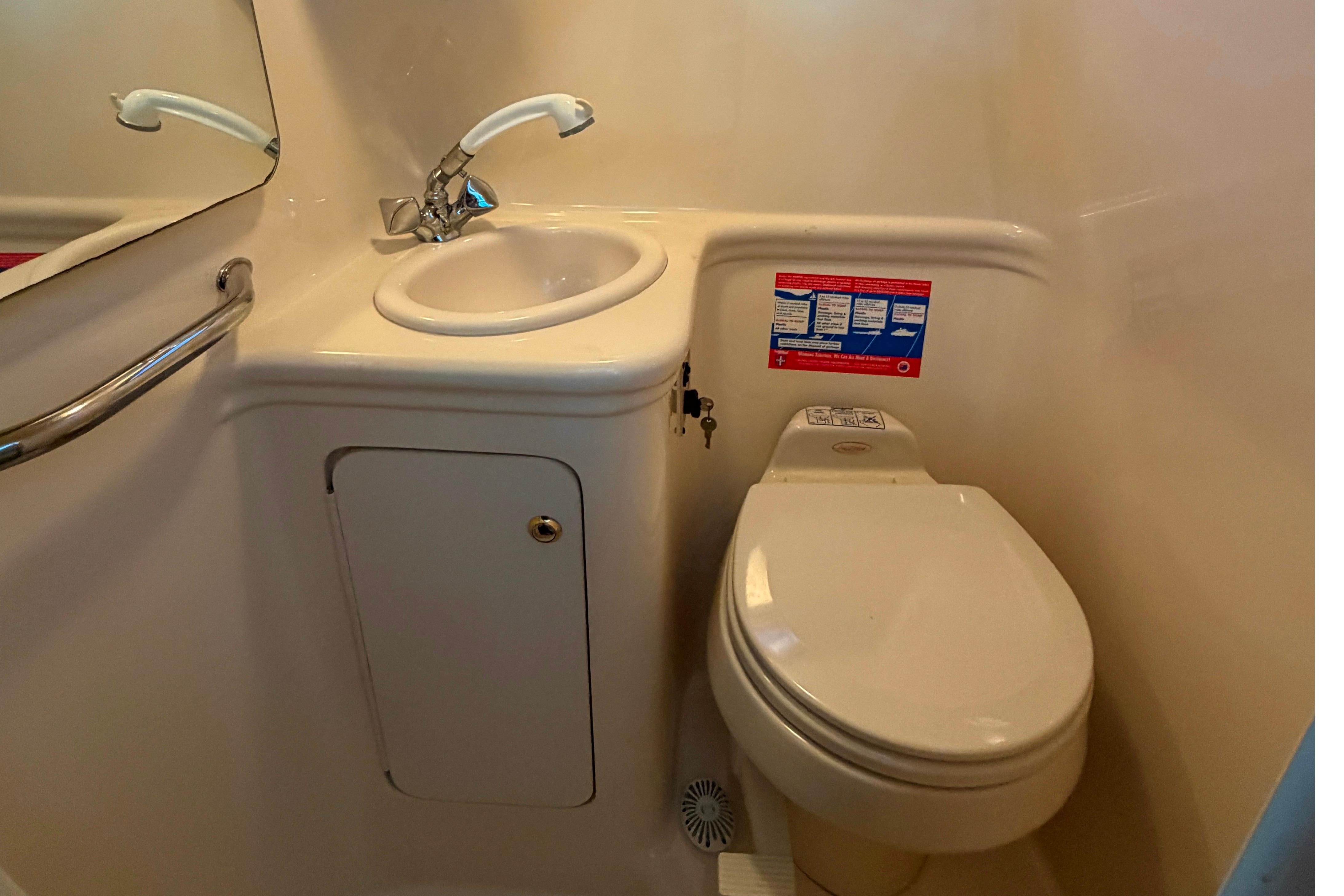 2004 Sea Ray Sundancer 260 bathroom with sink and toilet, compact marine design.
