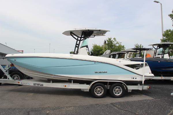 2023 Scarab 255 Open ID boat on trailer, light blue hull, parked outdoors.