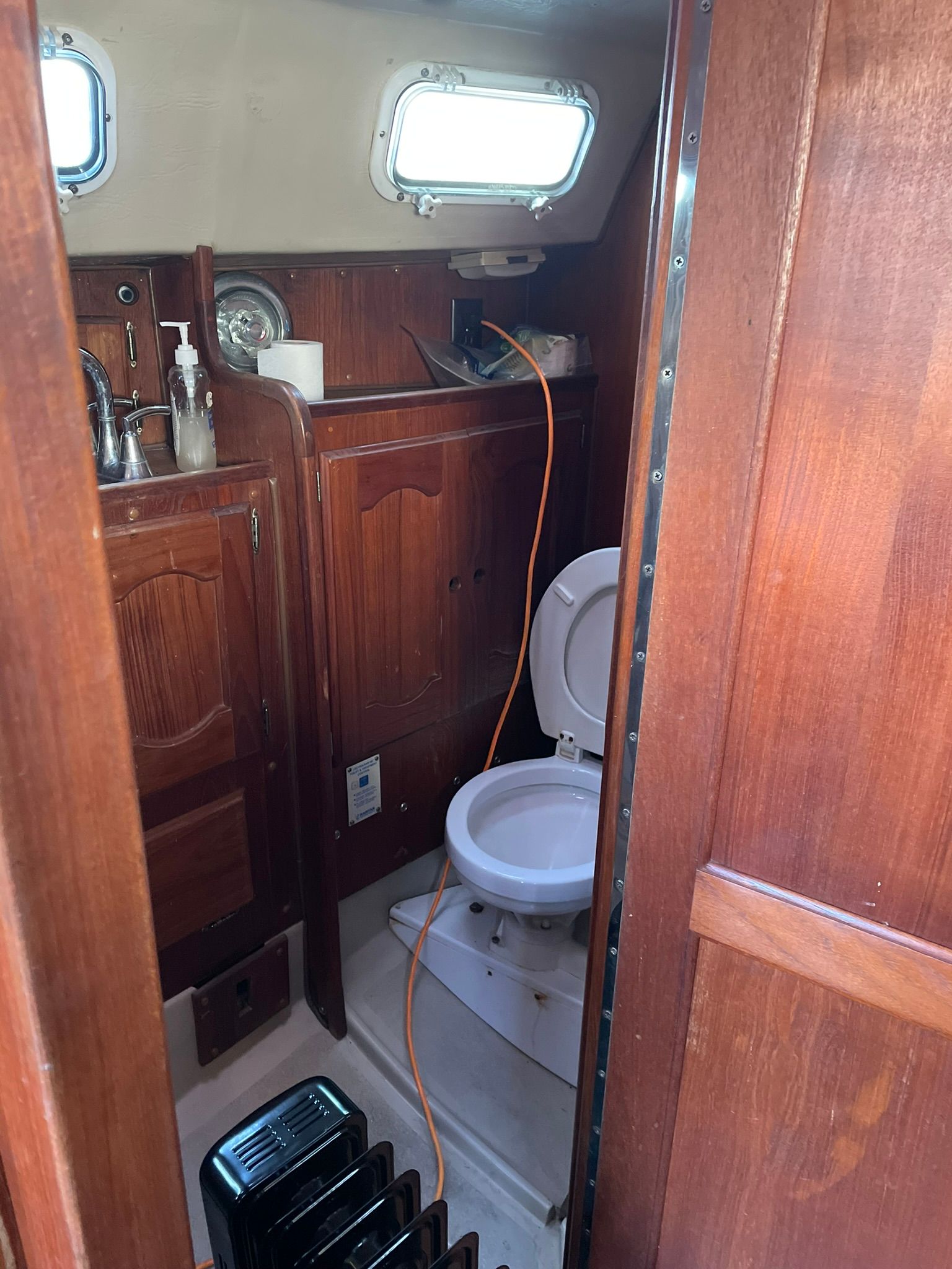 Interior of a 1982 Newport 33 with wooden cabinetry and a toilet.