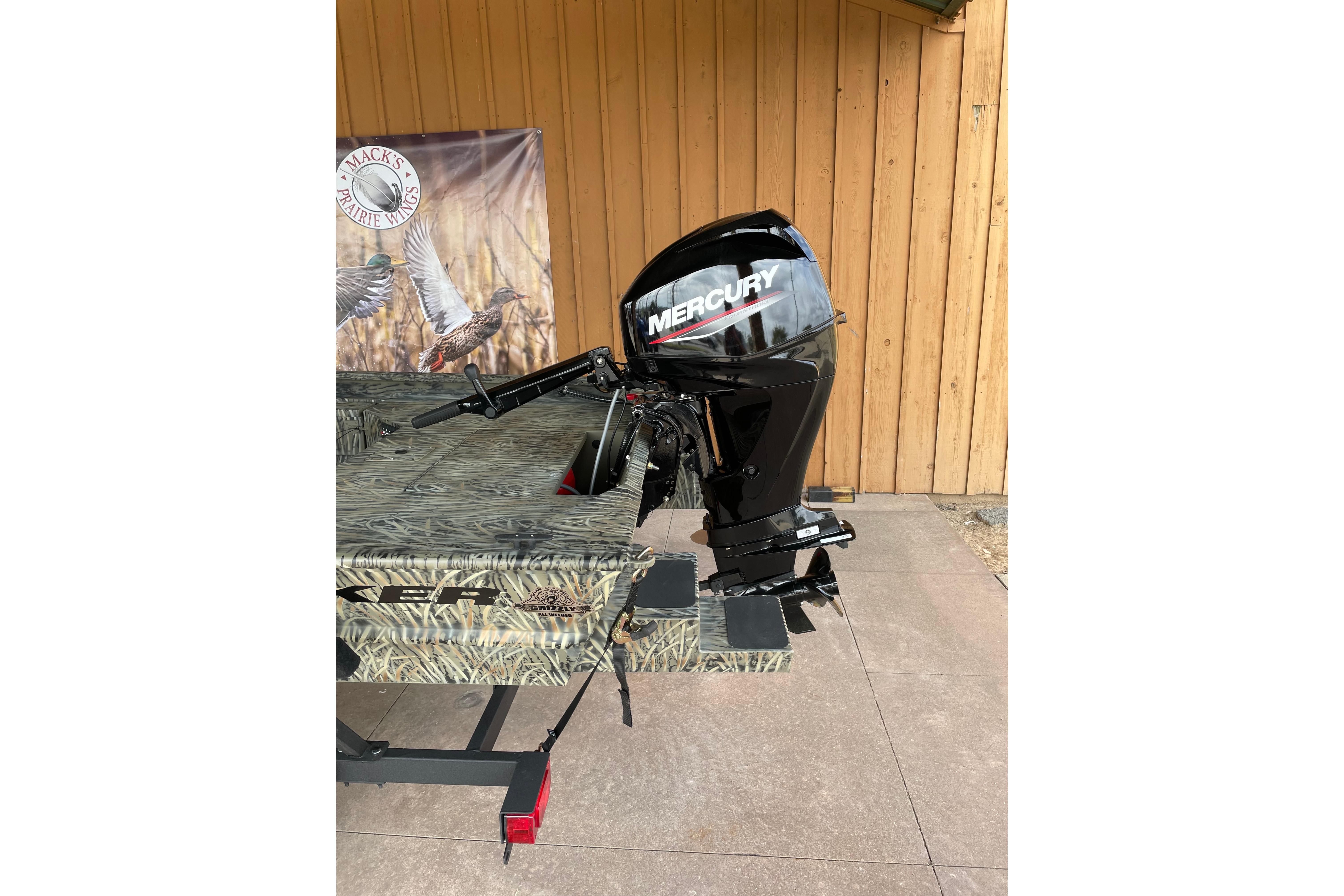 2026 Tracker Grizzly 1654 T Sportsman boat with Mercury outboard motor, camo design.
