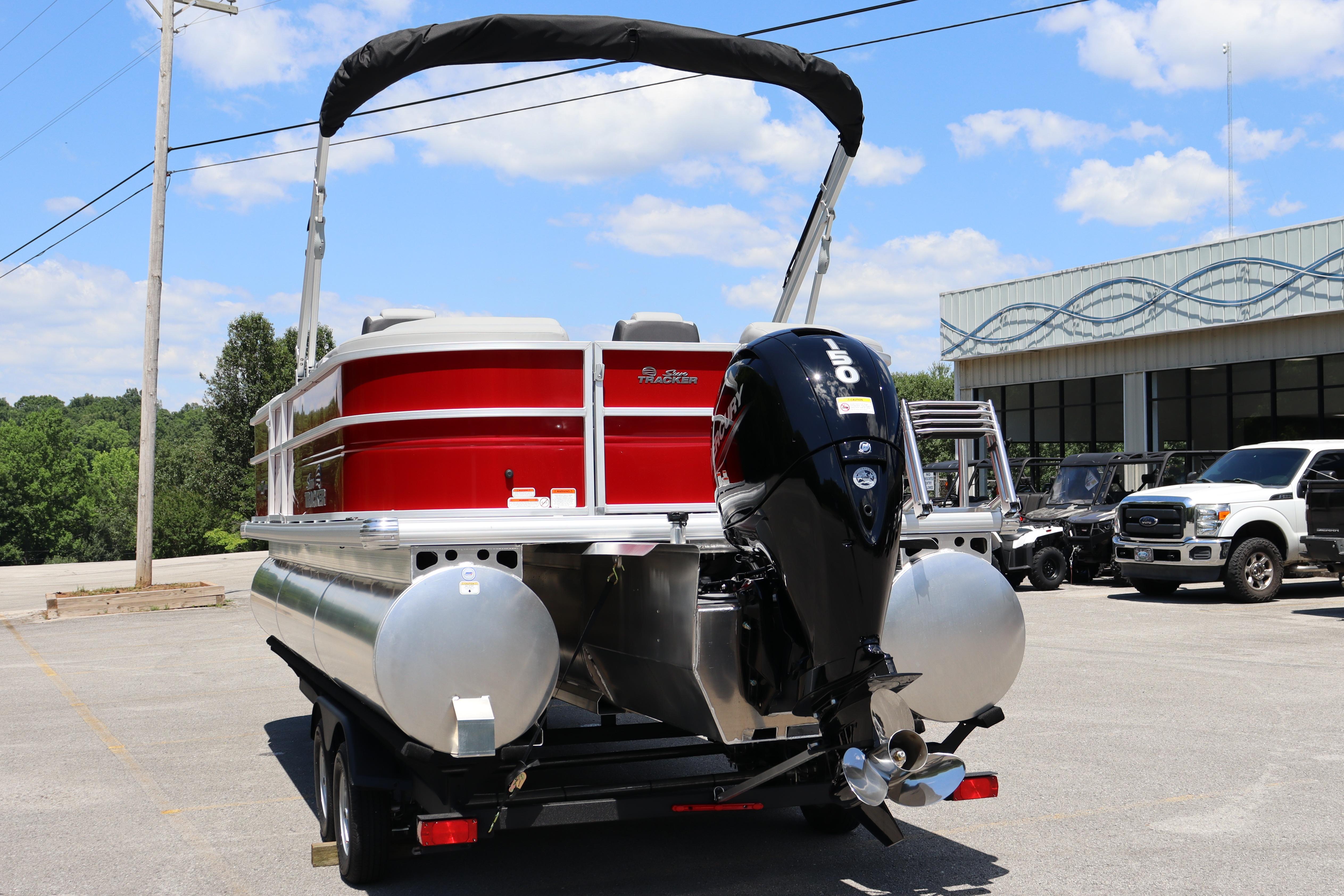 2026 Sun Tracker Party Barge 22 XP3 pontoon boat with outboard motor, parked outdoors.