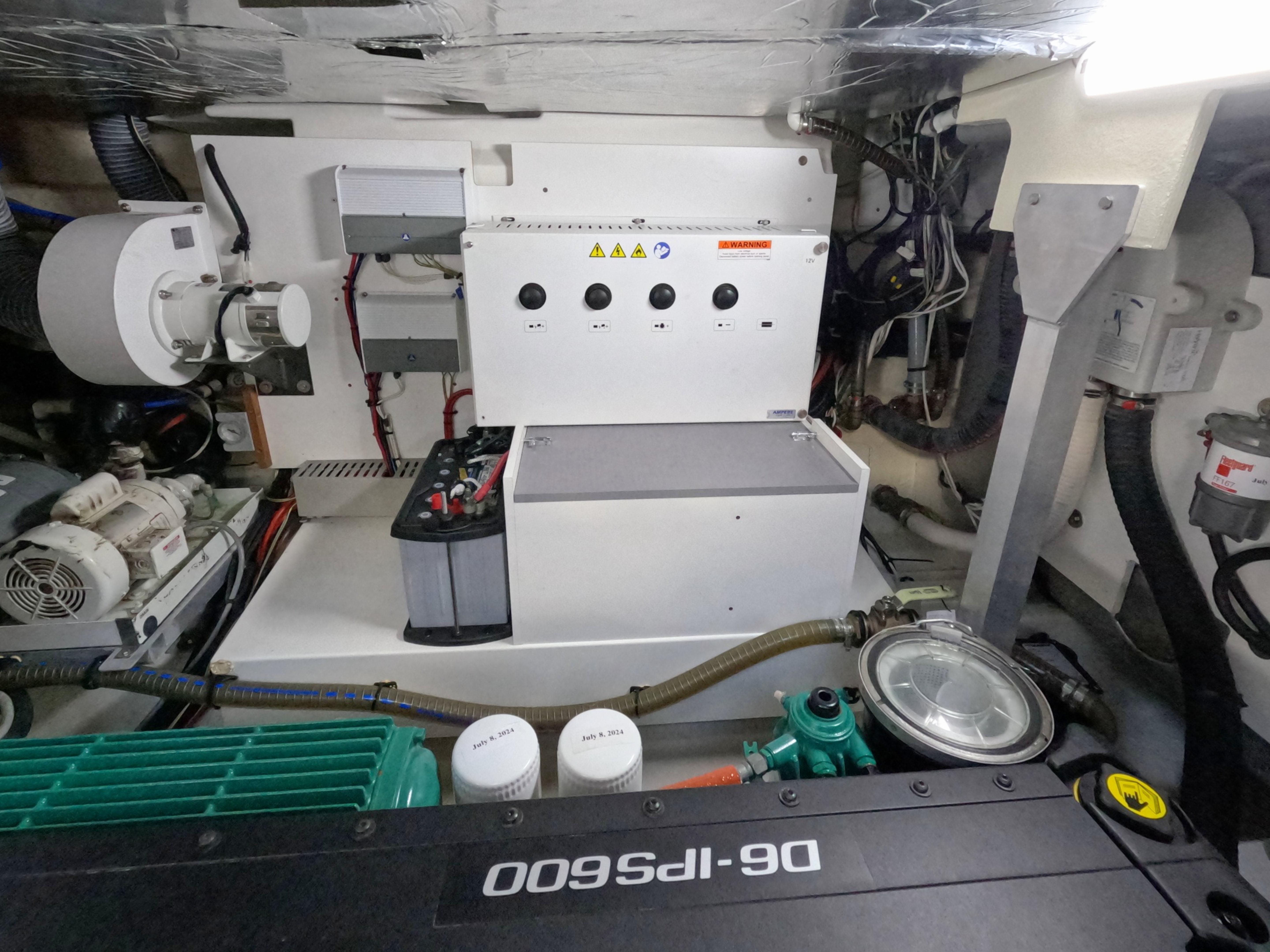 Engine room of 2020 Prestige 460 yacht with mechanical components and control panel.