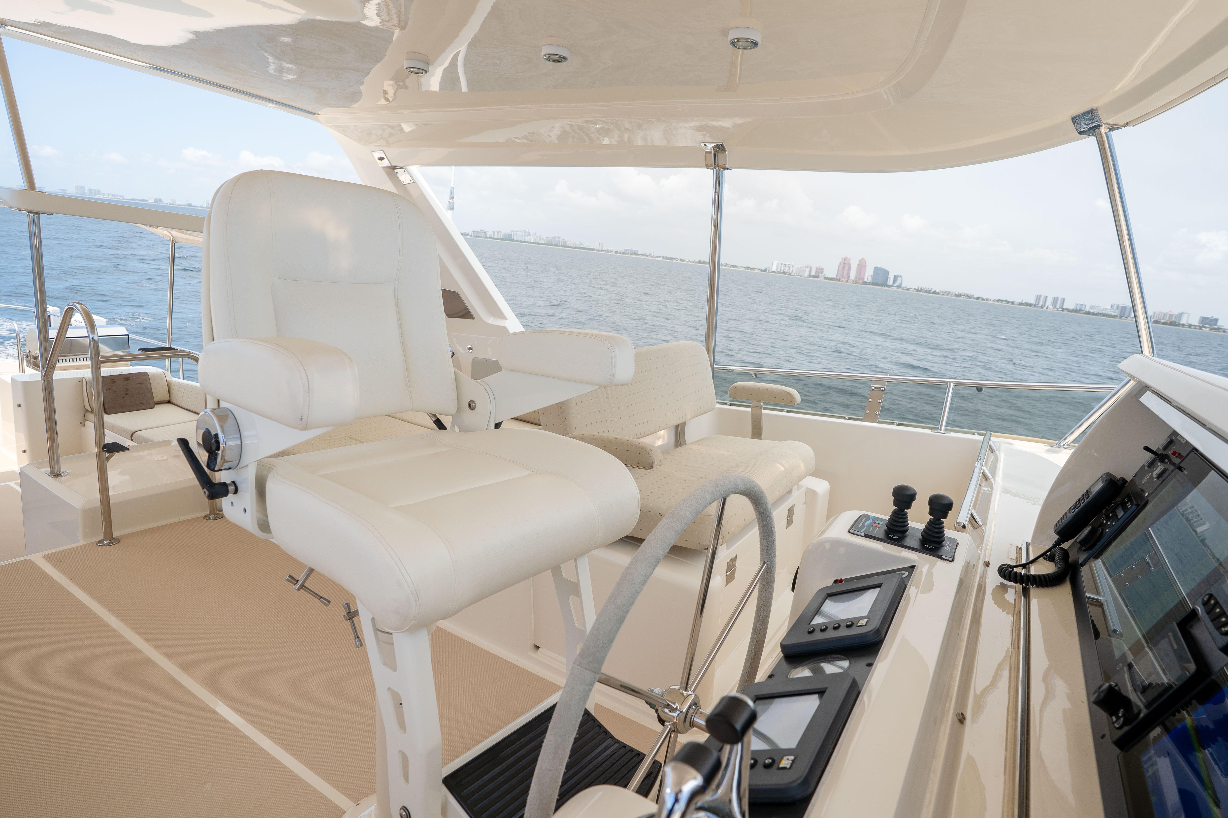 Helm of 2006 Fleming 75 yacht with white captain's chair and navigation controls.