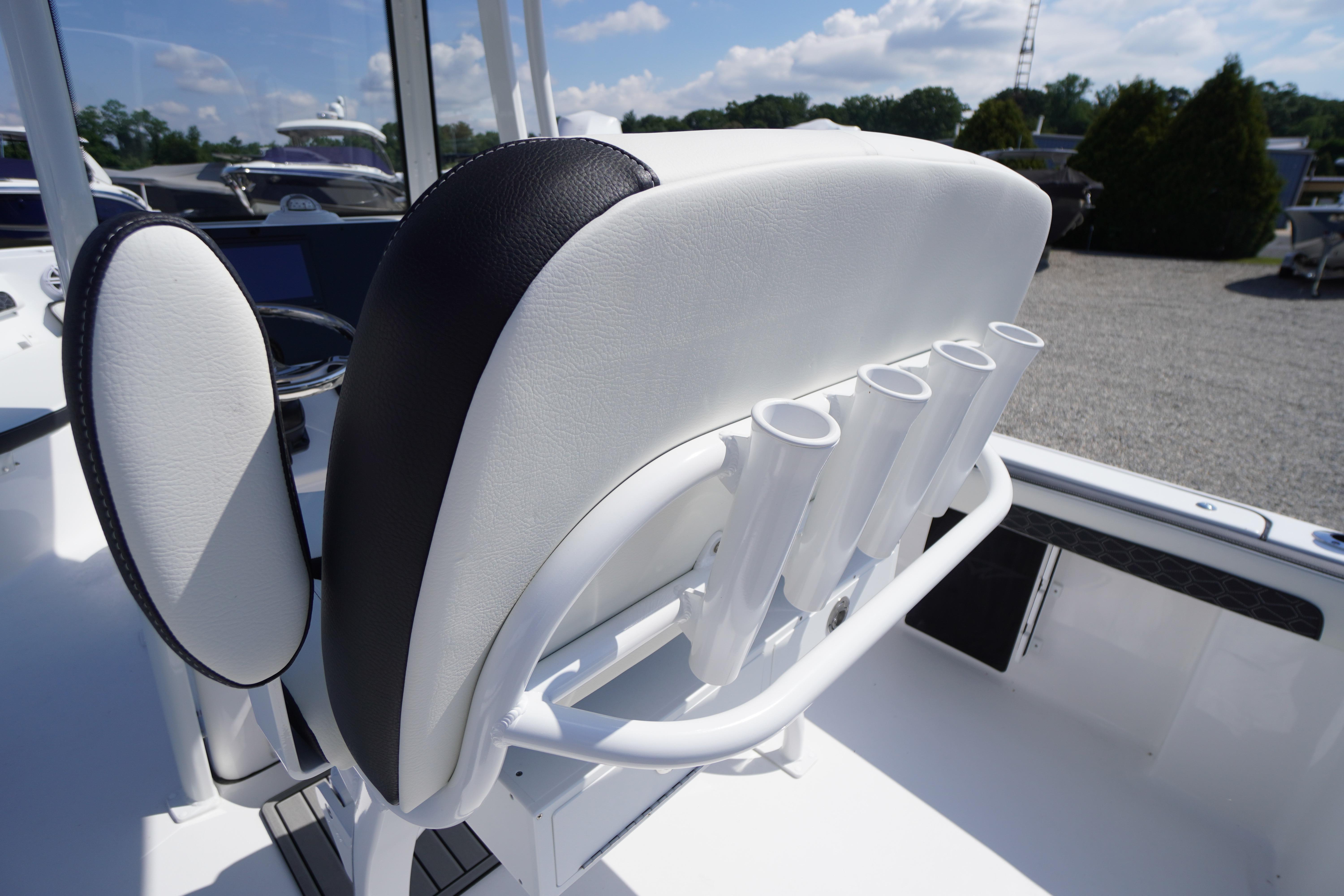 2026 Tidewater 220 CC Adventure boat seat with rod holders, outdoor setting.