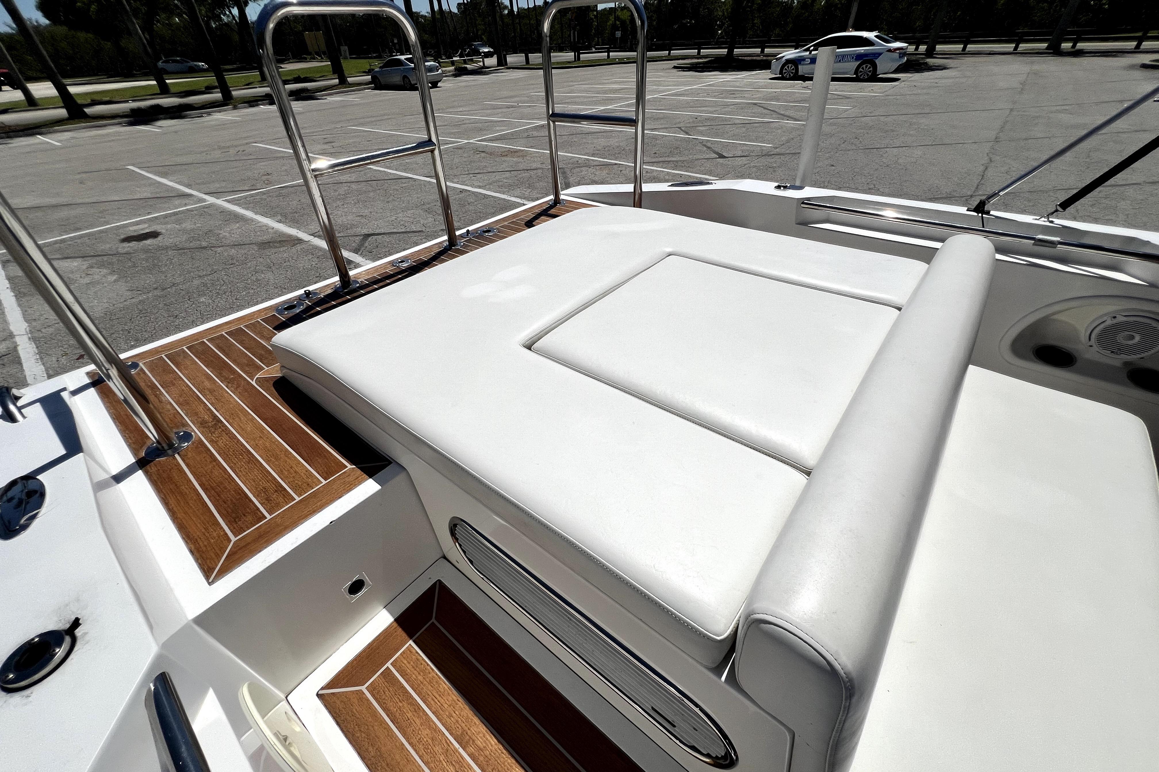 2013 Novurania Chase 23 boat with white seating and wooden deck in a parking lot.