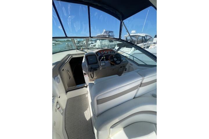 2005 Sea Ray Sundancer 320 cockpit with helm, seating, and marina view.