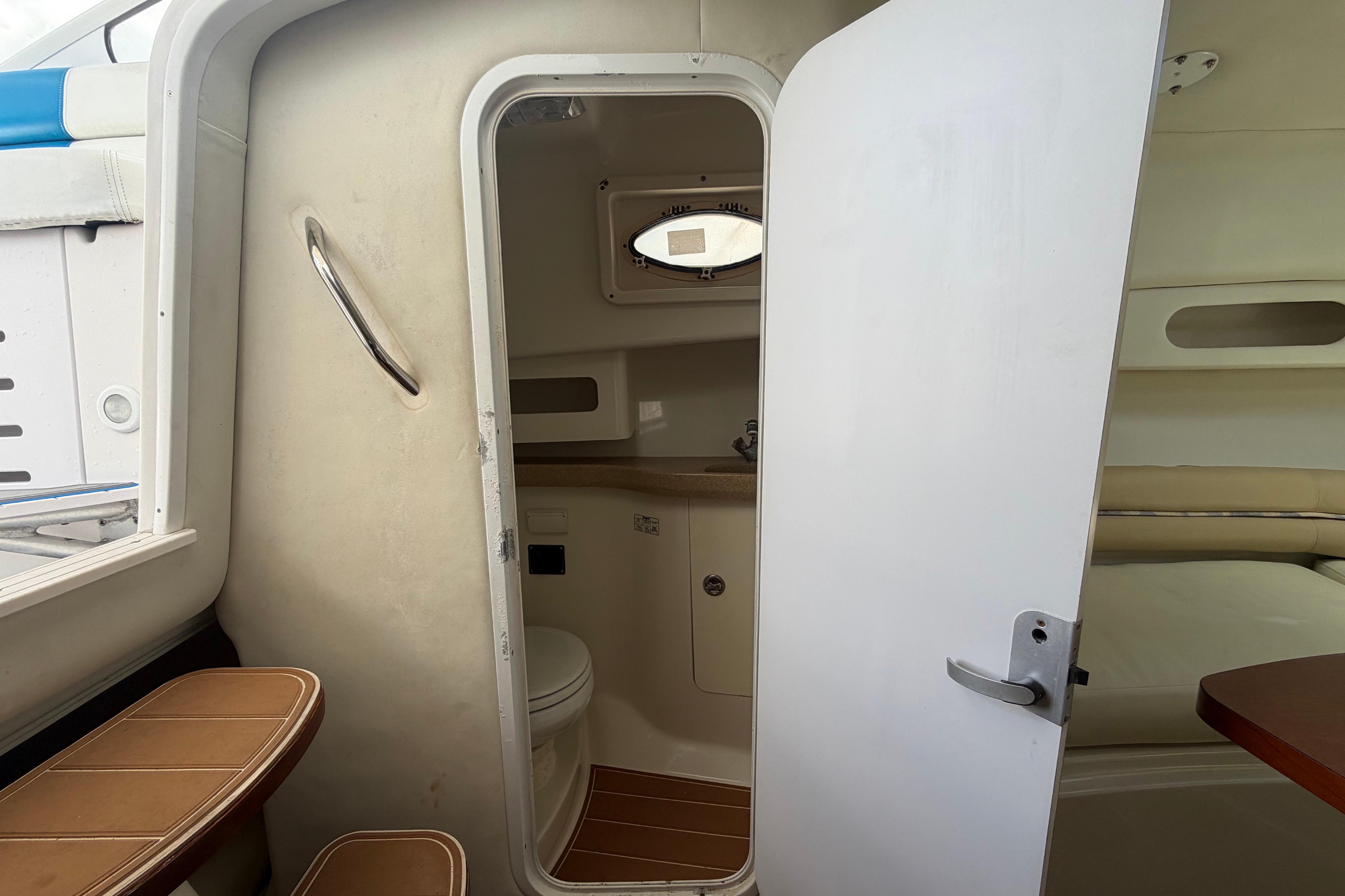 2007 Pro-Line 32 Express cabin interior with open door, showing bathroom and seating area.