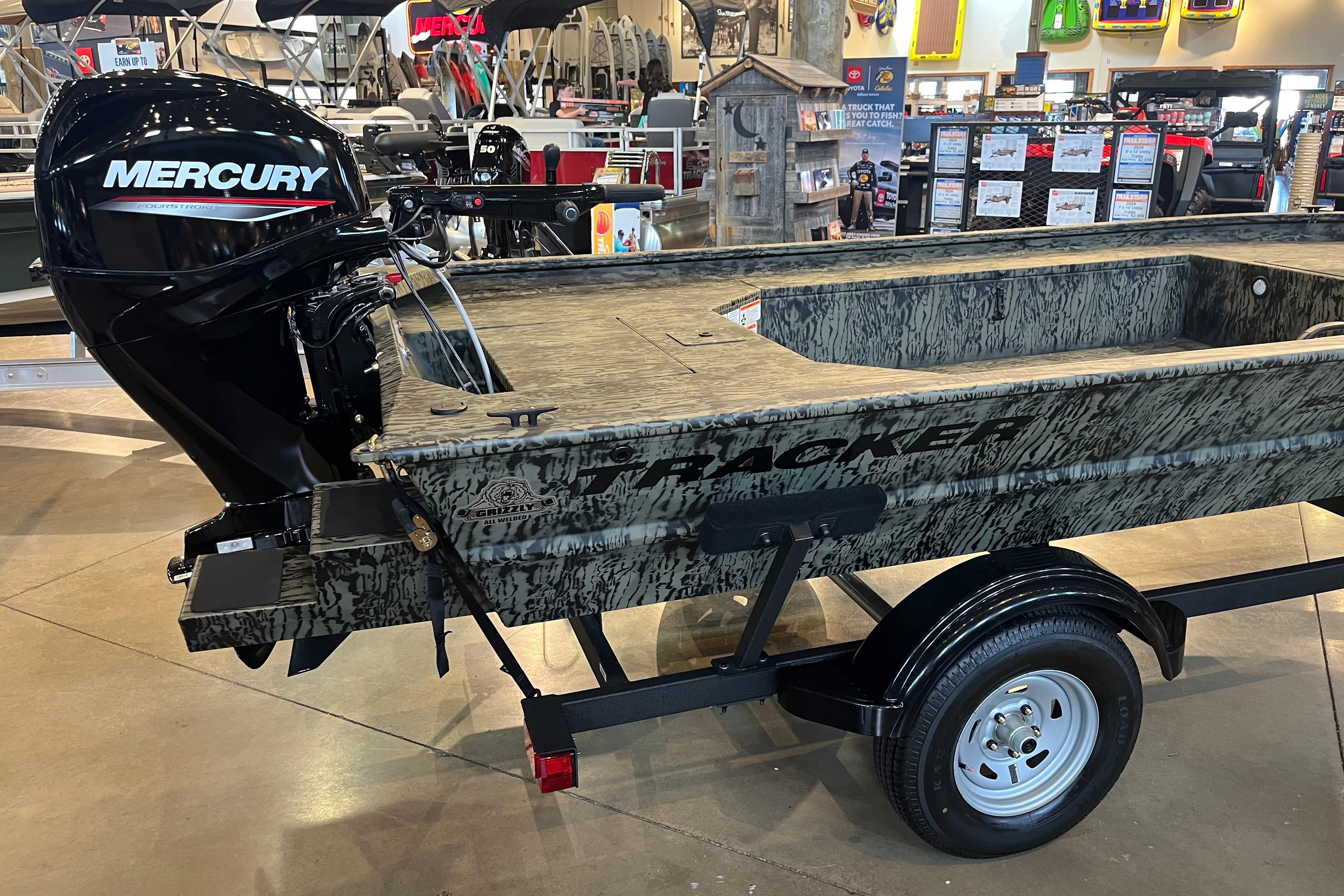 2026 Tracker Grizzly 1654 T Sportsman boat with Mercury engine on display.