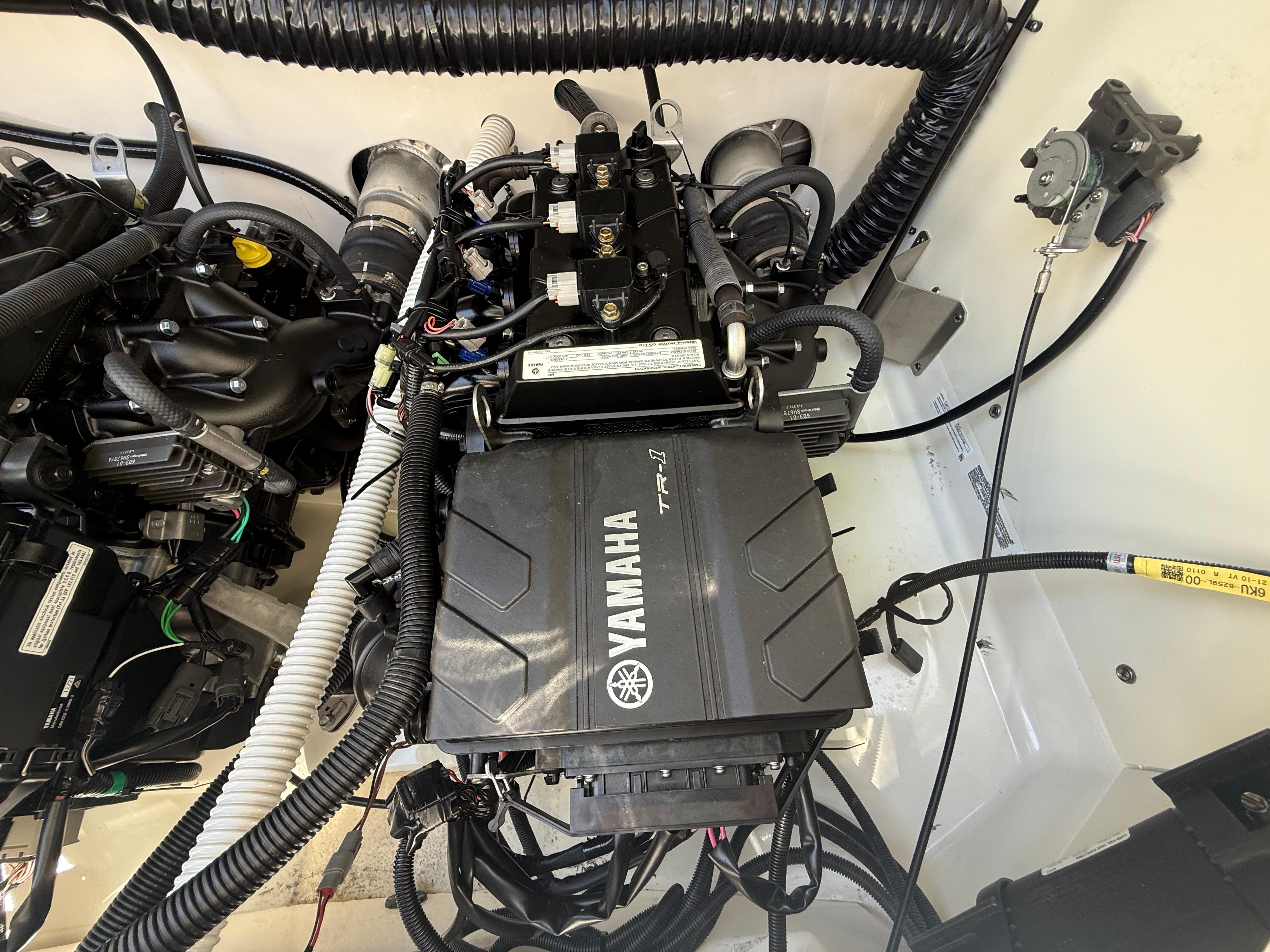 Engine compartment of a 2022 Yamaha Boats AR210, showcasing intricate wiring and components.