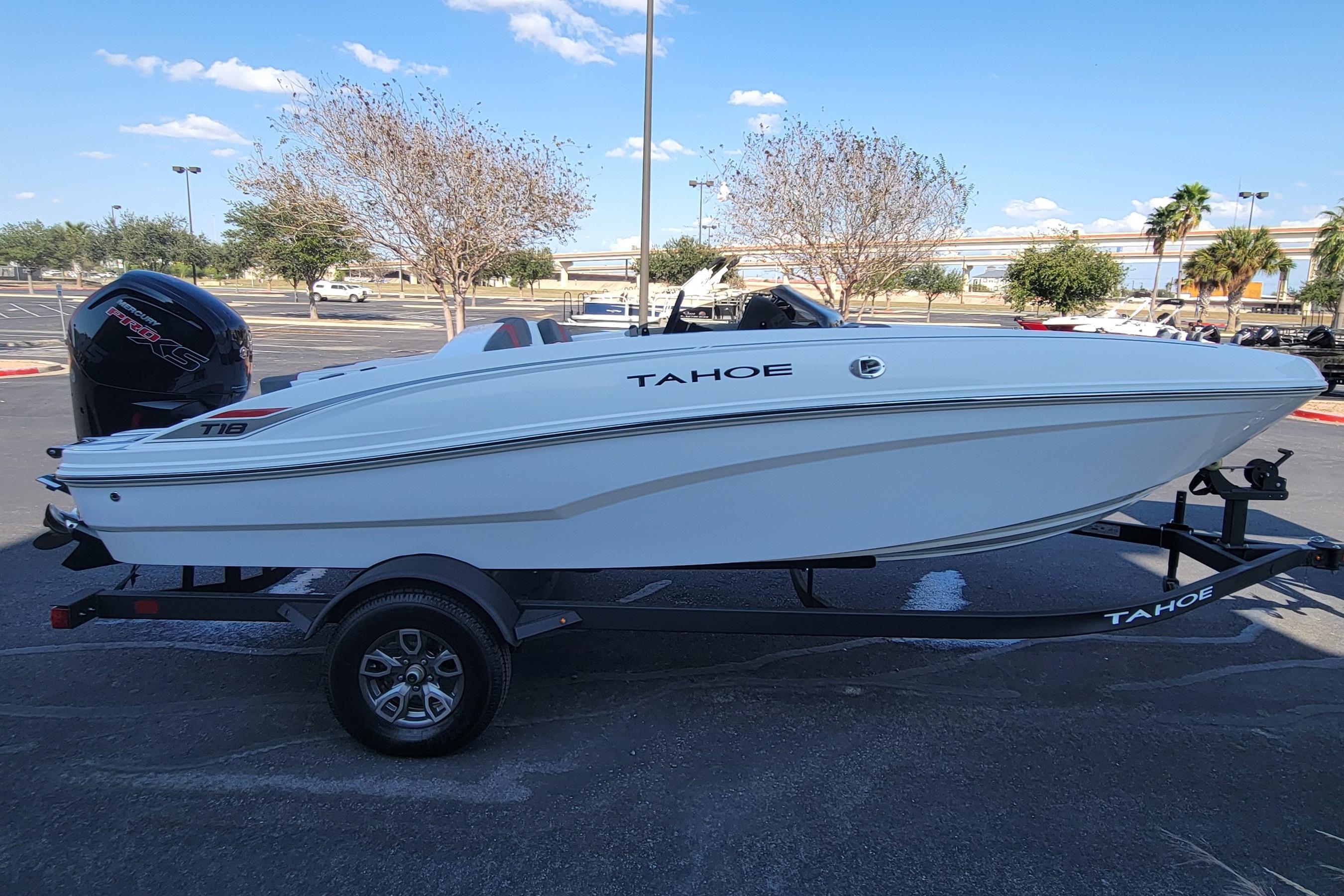 2025 Tahoe T18 boat on trailer in parking lot, clear sky background.