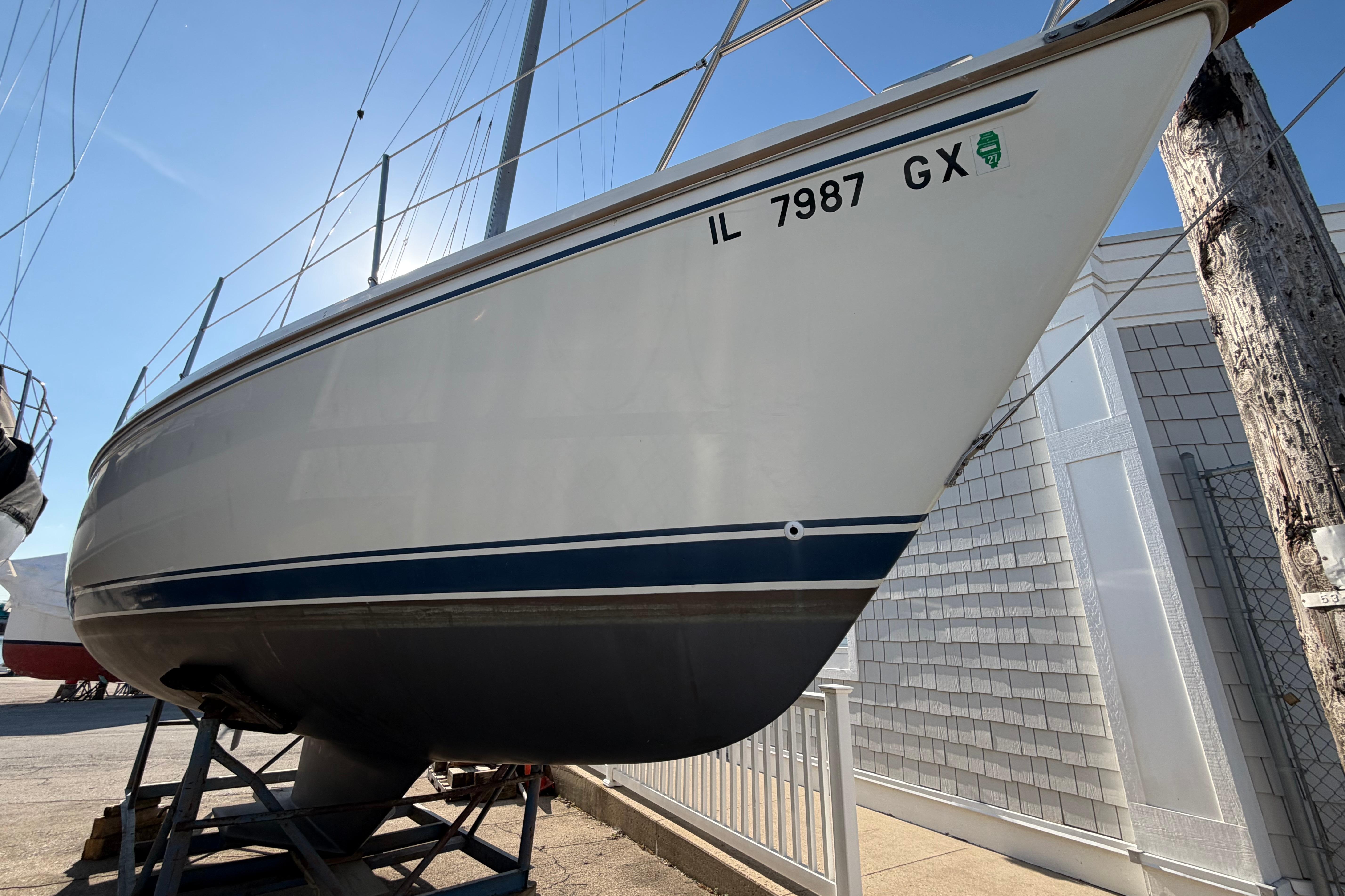 1988 Catalina 30 MkII sailboat on stands, registration IL 7987 GX, sunny day.